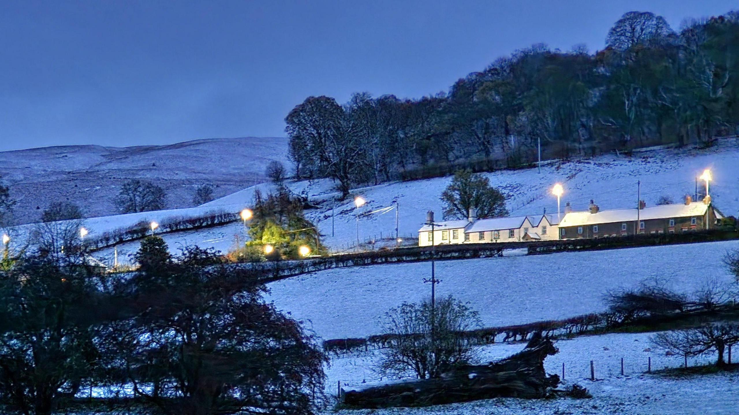 Pentref Glyndyfrdwy yn Sir Ddinbych dan drwch o eira wrth iddi wawrio bore Mercher