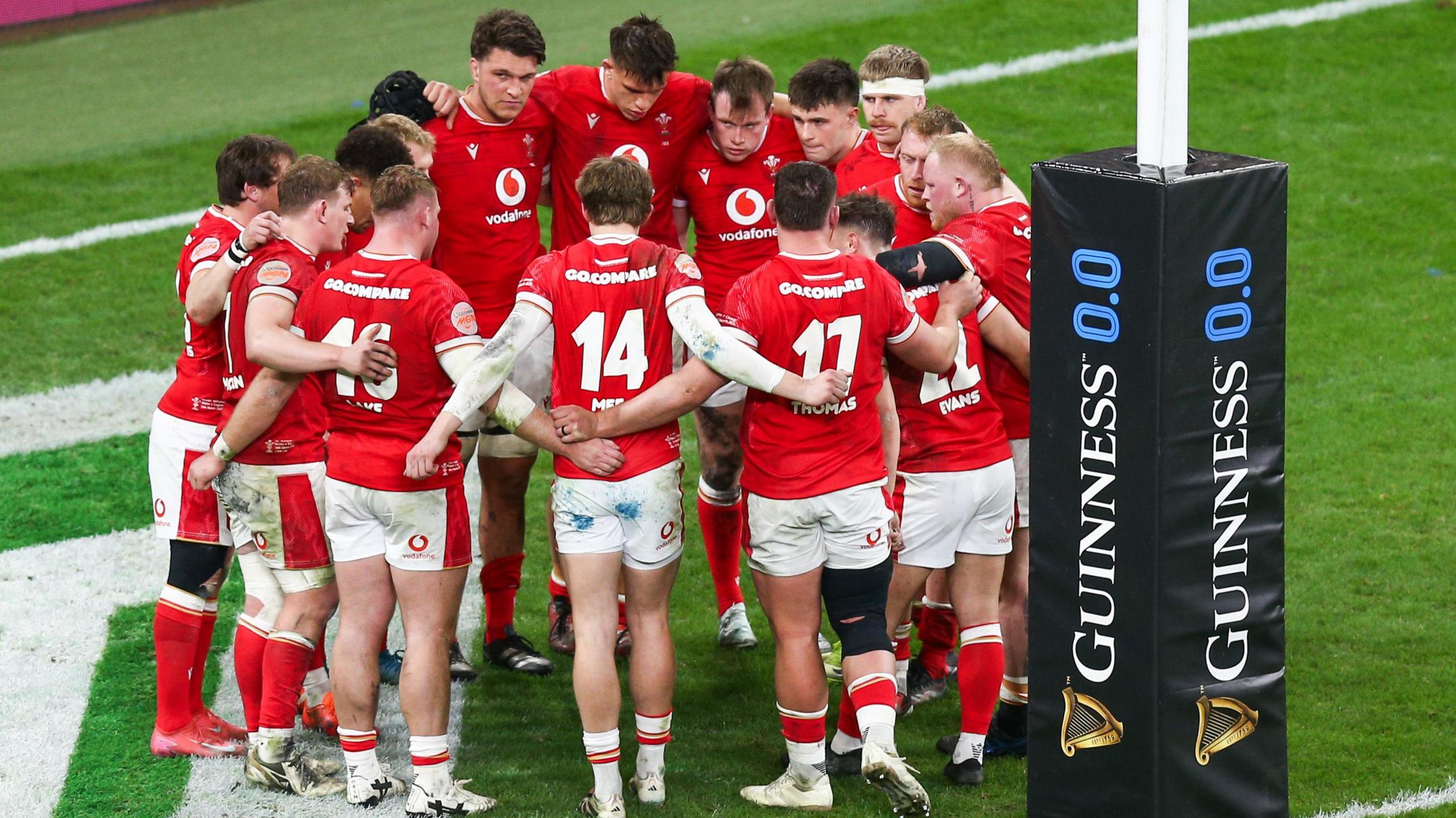 Wales players stand in a huddle after loss to England