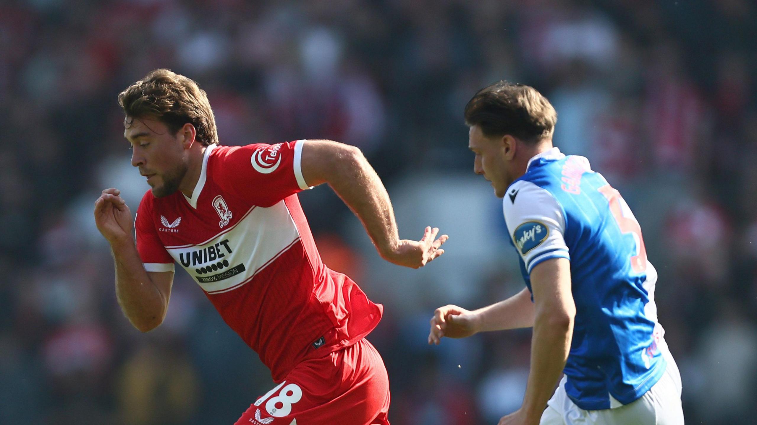 Middlesbrough player Aidan Morris (left) is being chased by Blackburn midfielder Taylor Gardner-Hickman (right)