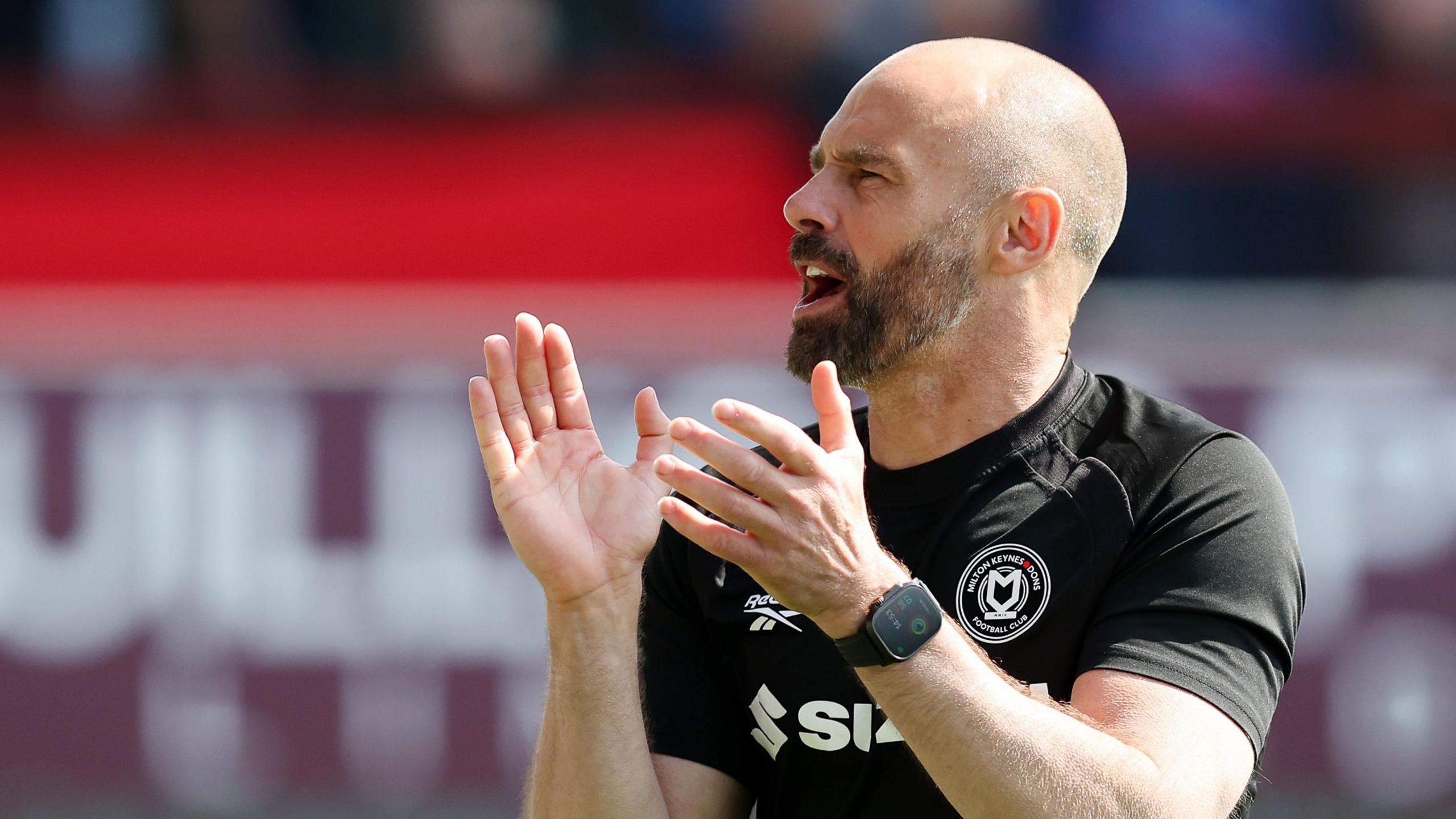 MK Dons boss Paul Warne claps his hands
