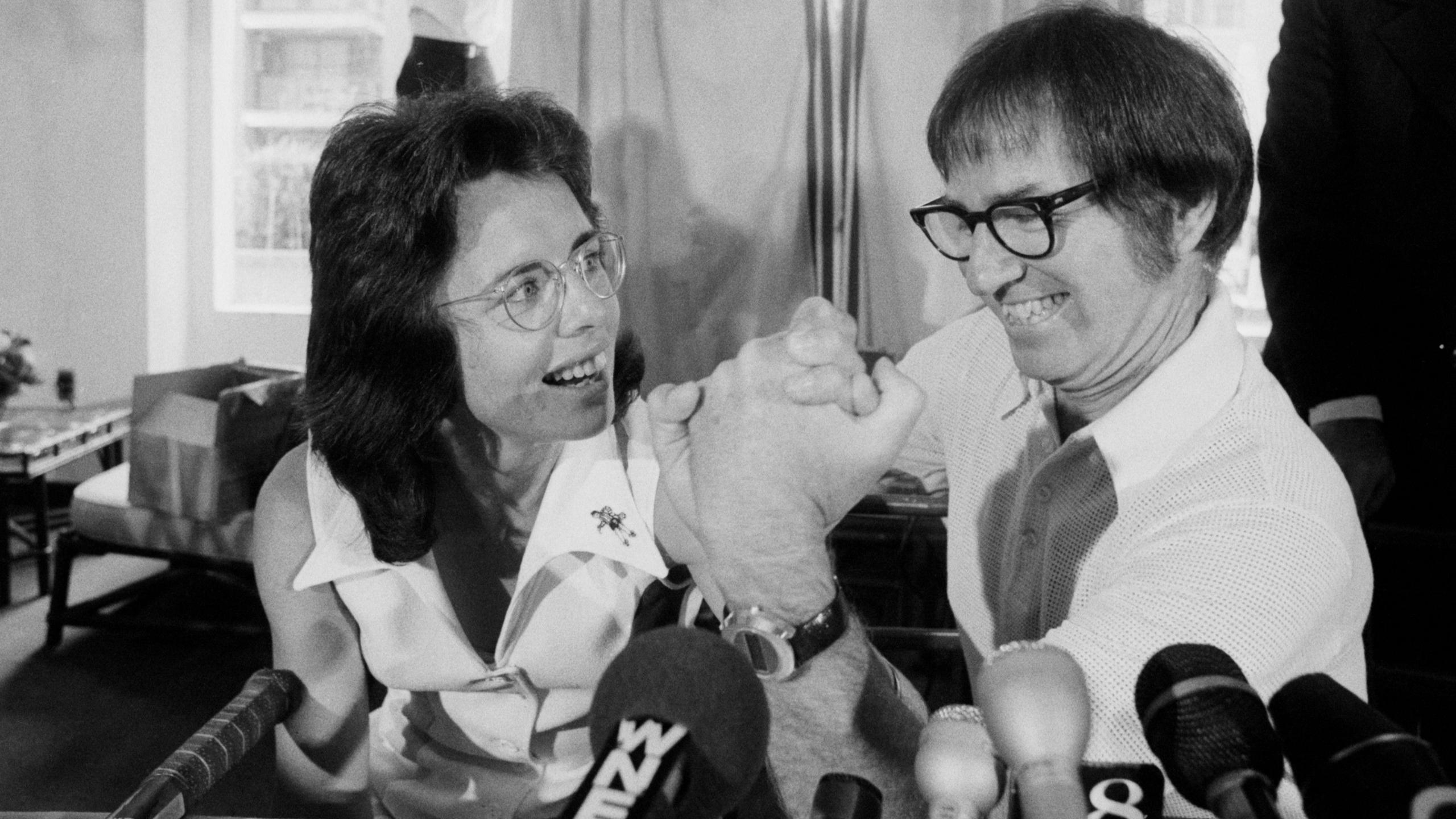 Bobby Riggs and Billie Jean King arm wrestle at a news conference in July 1973
