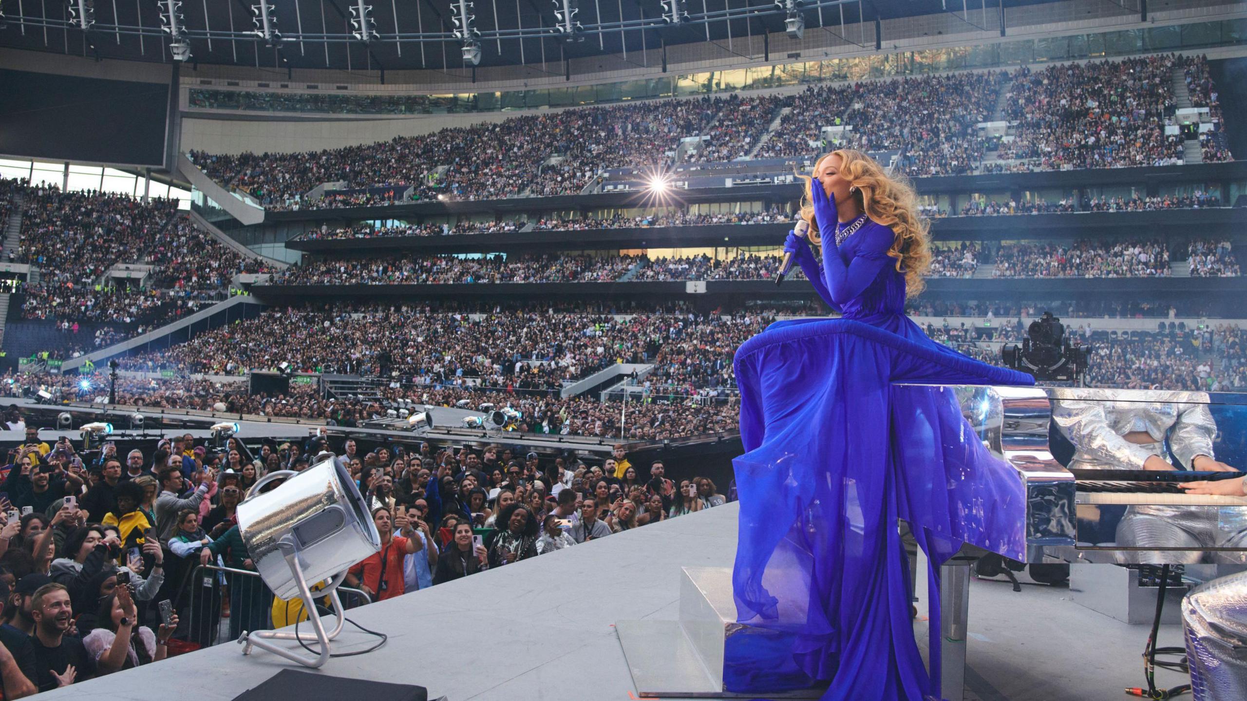 Beyonce stands on stage wearing a blue dress at the Tottenham Hotspur Stadium in May 2023