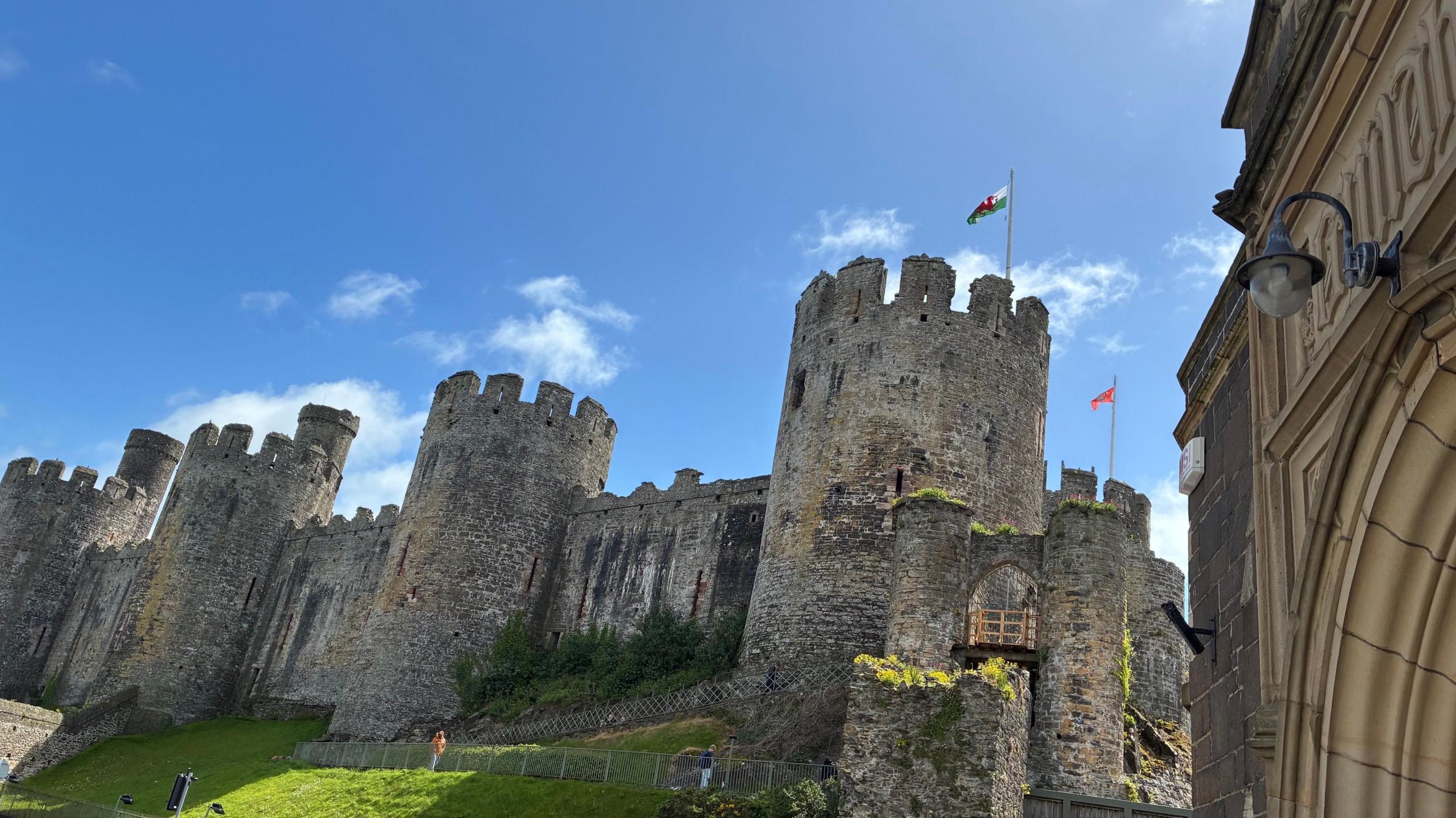 Llun o Gastell Conwy yn edrych i fyny at ochr gogleddol yr adeilad gyda'r 4 twr i'w gweld 