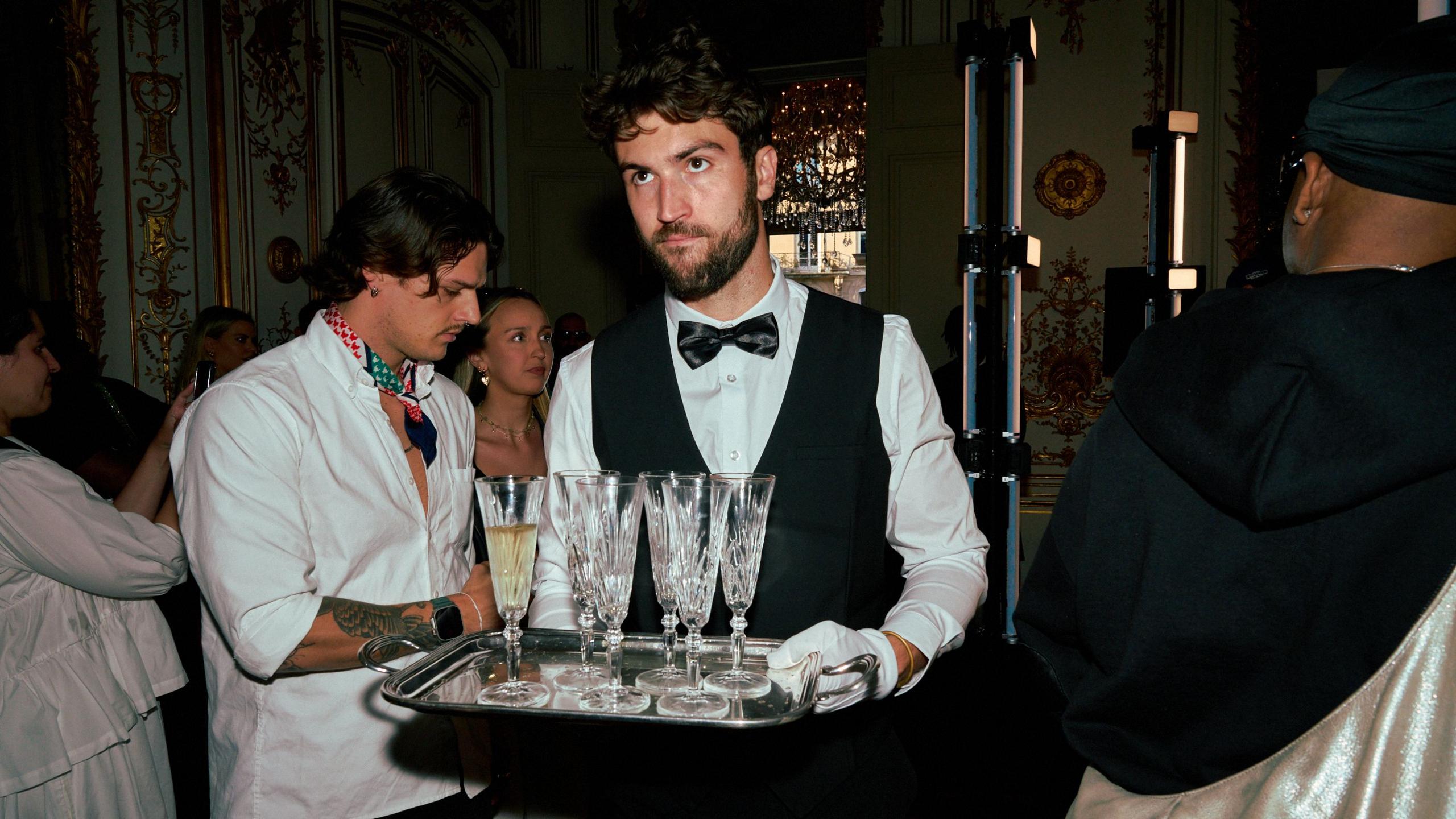 Waiters serve champagne to guests 