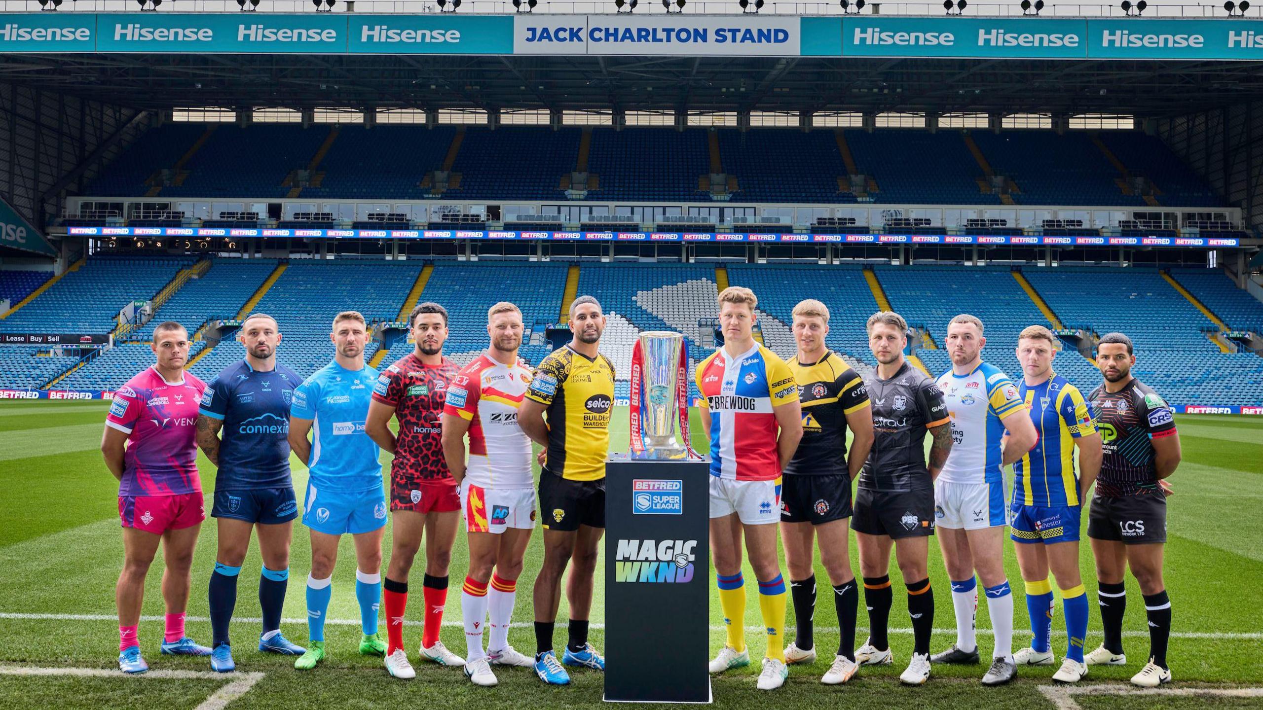 Representatives of all 12 Super League clubs pose for a promotional photograph with the competition trophy at Elland Road, the Magic Weekend venue for 2024