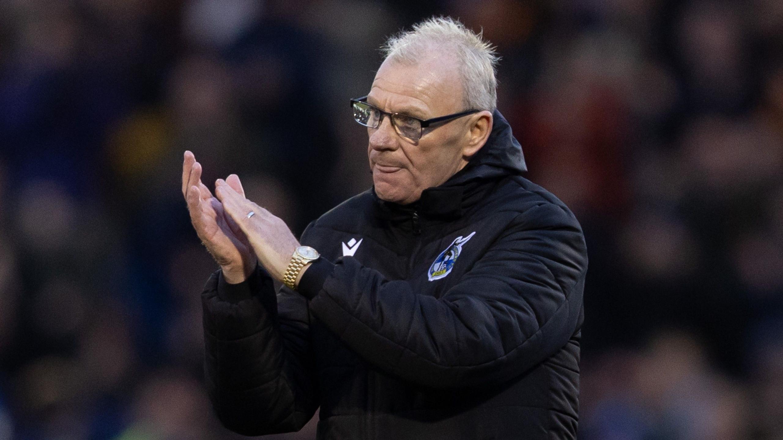 Bristol Rovers manager Steve Evans claps his hands while walking on the pitch
