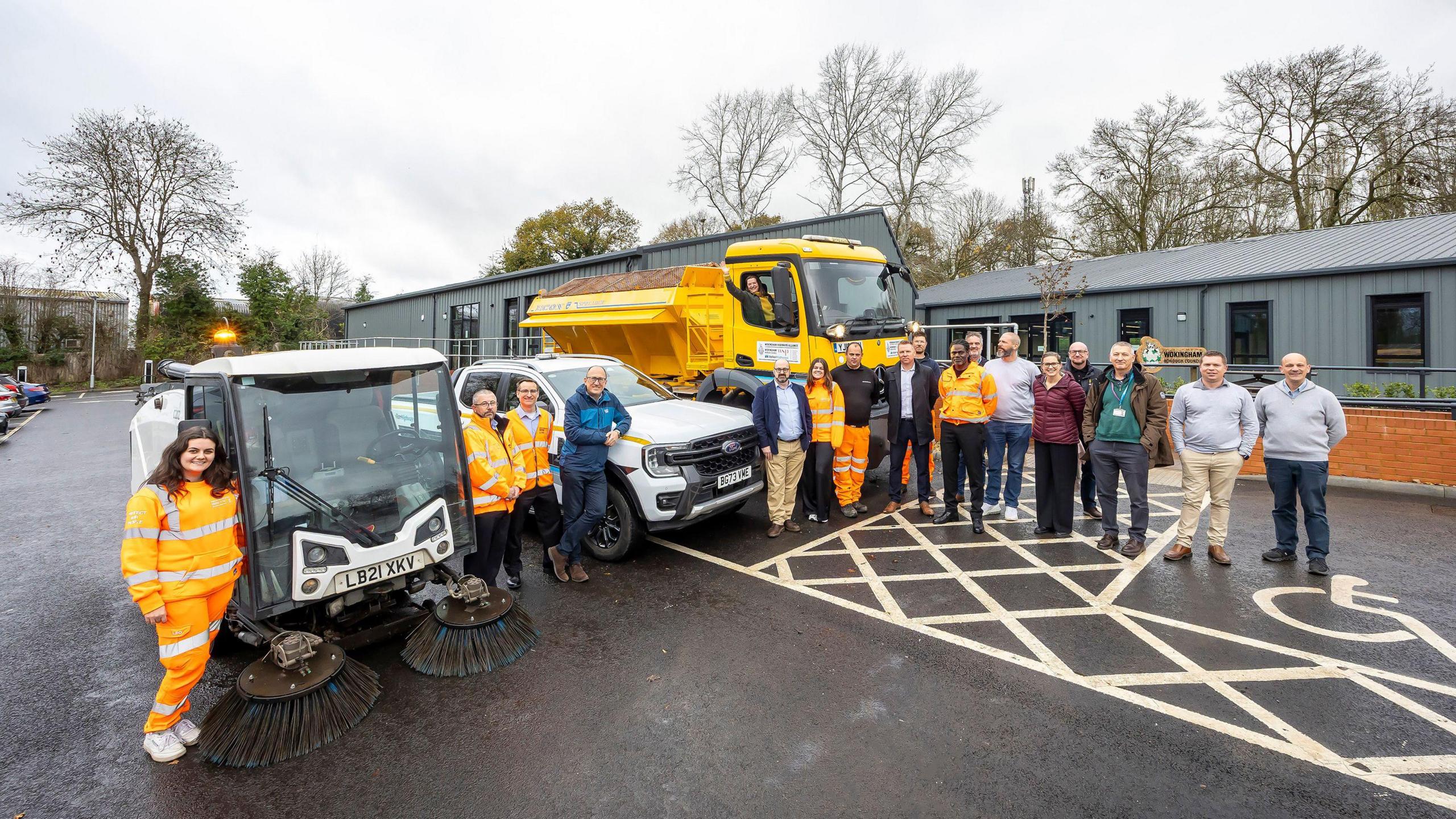 Wokingham Borough Council staff and offices posing in front of their new offices with a gritter, a response vehicle and a road sweeper.
