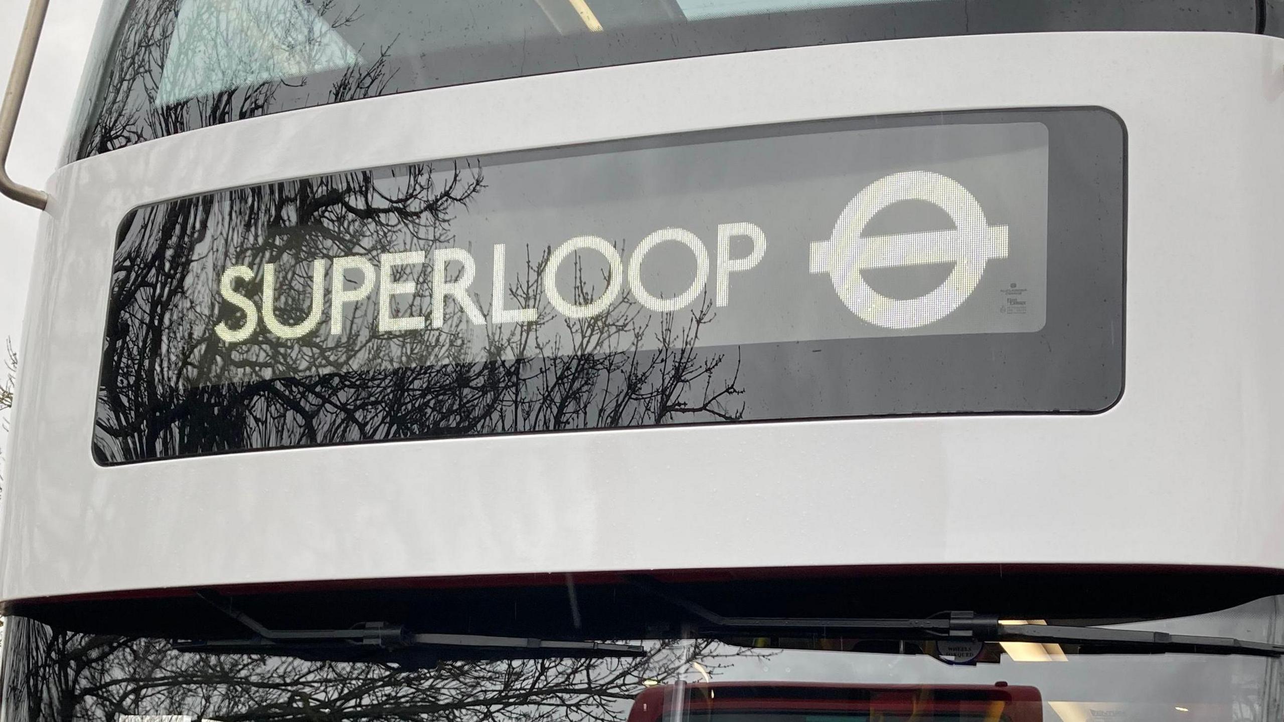 A close up of the Superloop sign on the front of a London bus. The London Transport roundel is also visible. 