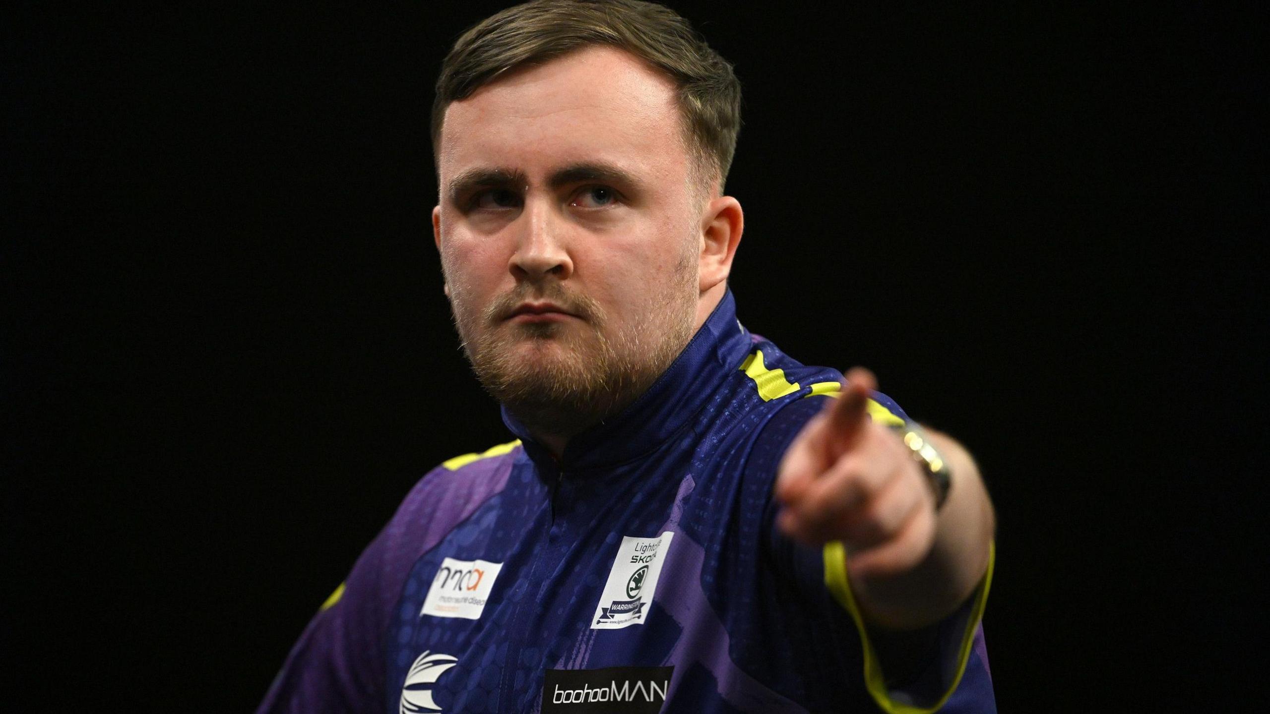 Luke Littler points to the camera after another 180