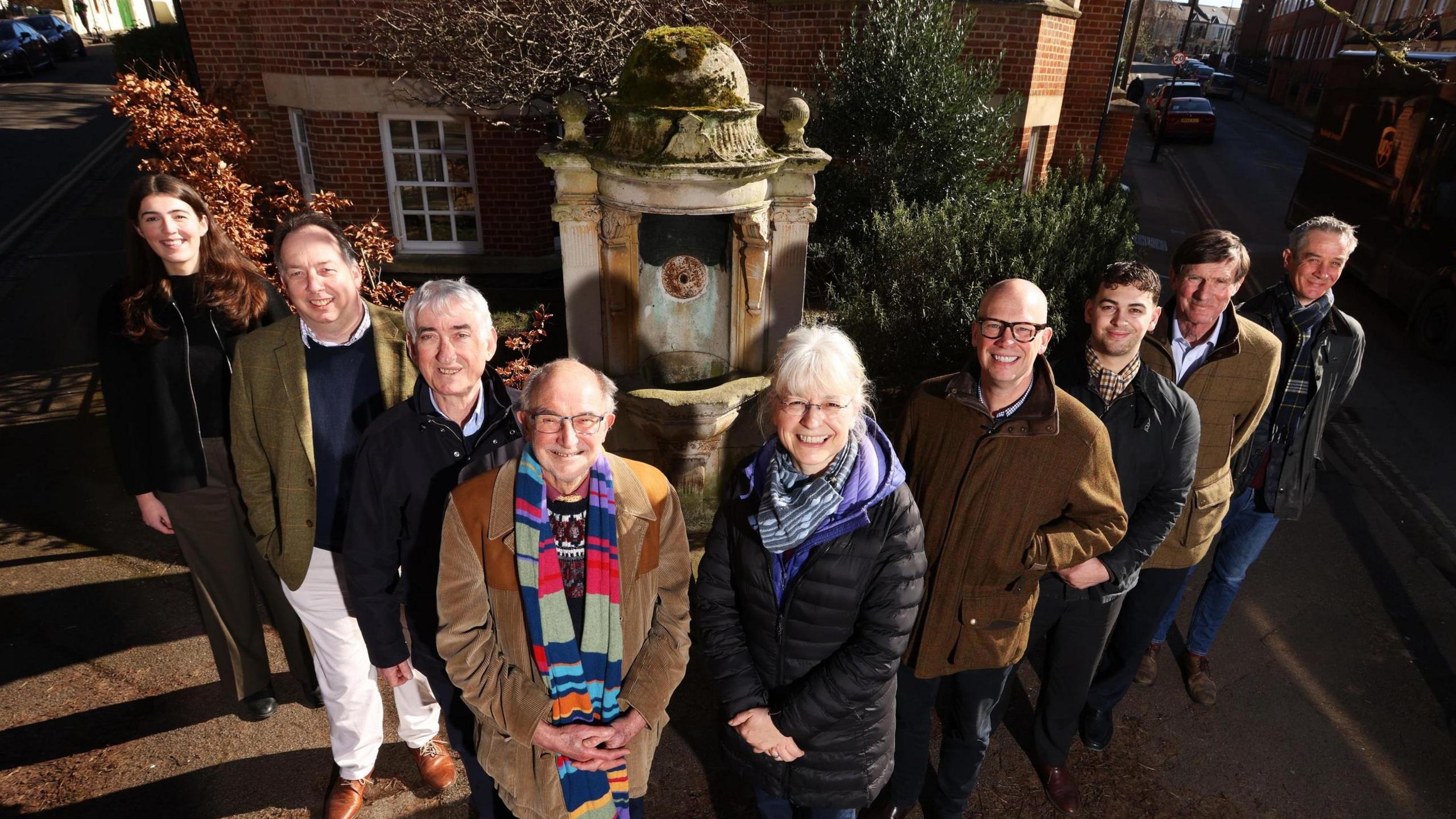 Nine members of the Oxford Preservation Trust stood in front of the fountain.