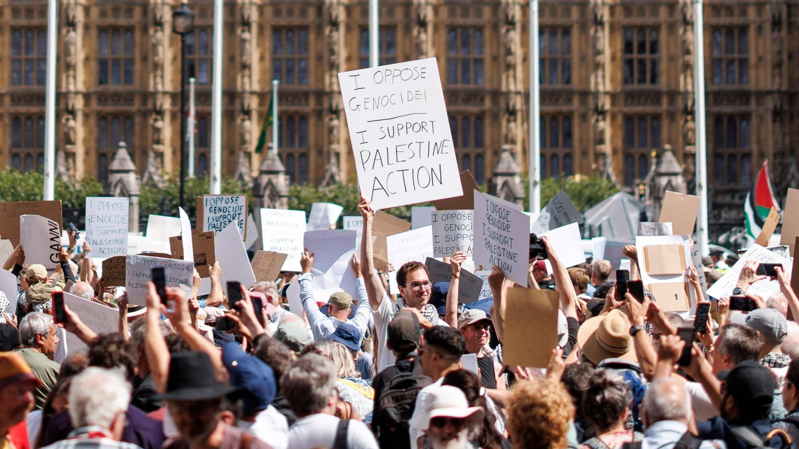 Protestors at Parliament Square holding up placards saying I oppose genocide, I support Palestine Action