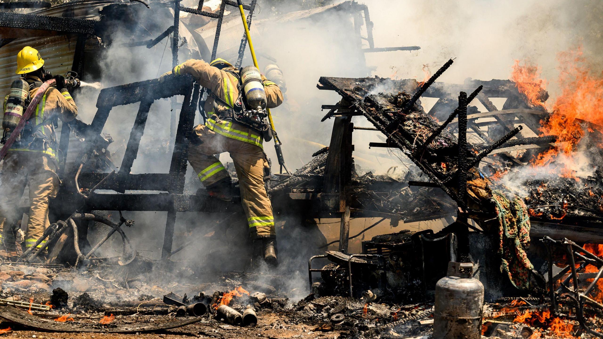 Firefighters knock down a structure fire that ignited during the Thompson wildfire in Oroville, California on 3 July, 2024