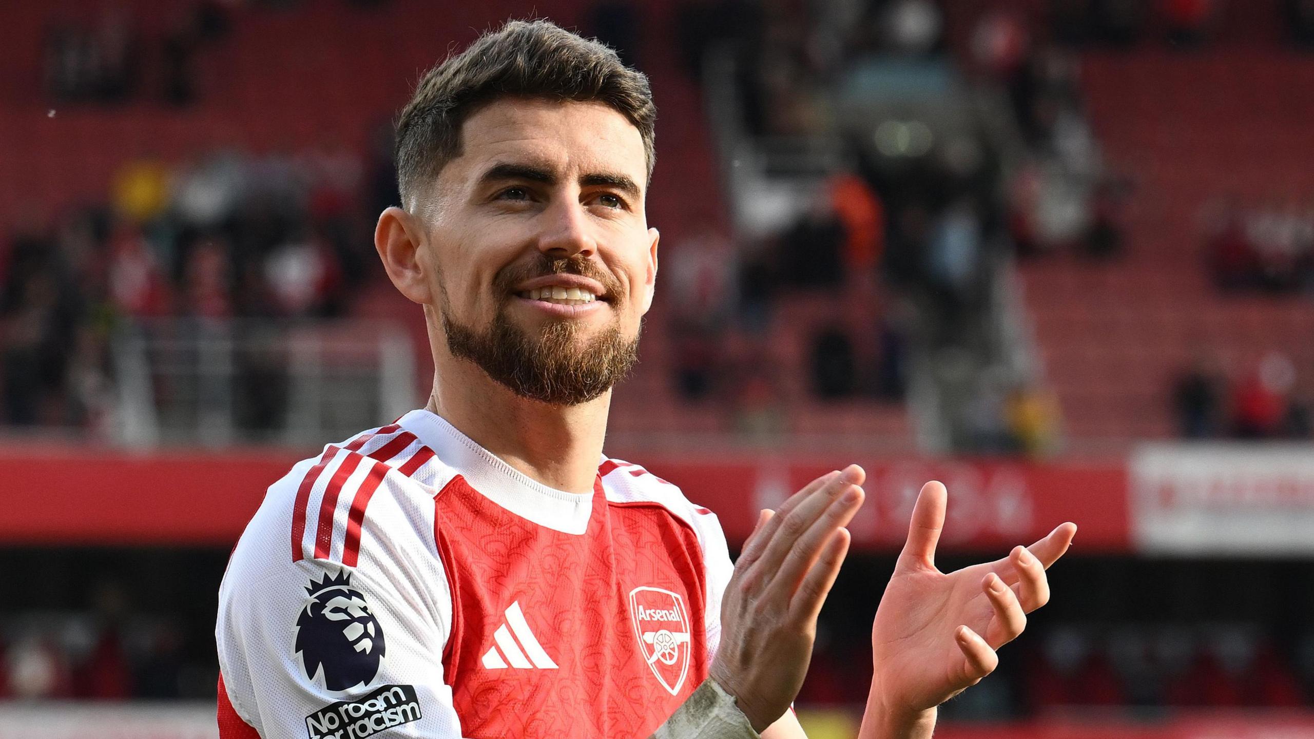 Jorginho wearing an Arsenal shirt applauding fans