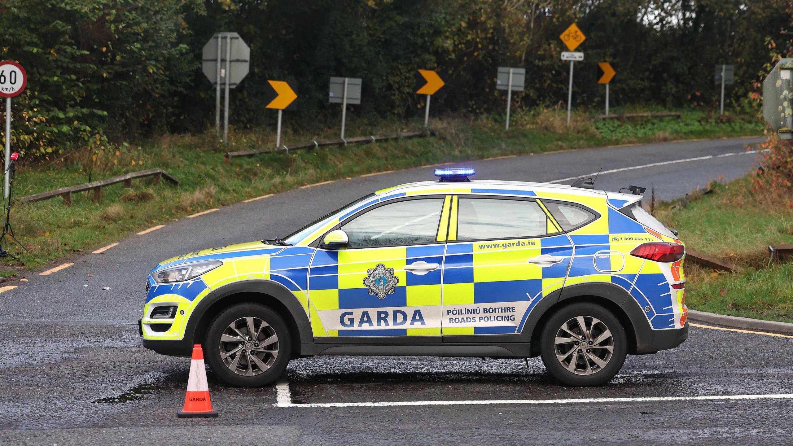 A garda patrol card blocking a road. There are traffic cones.