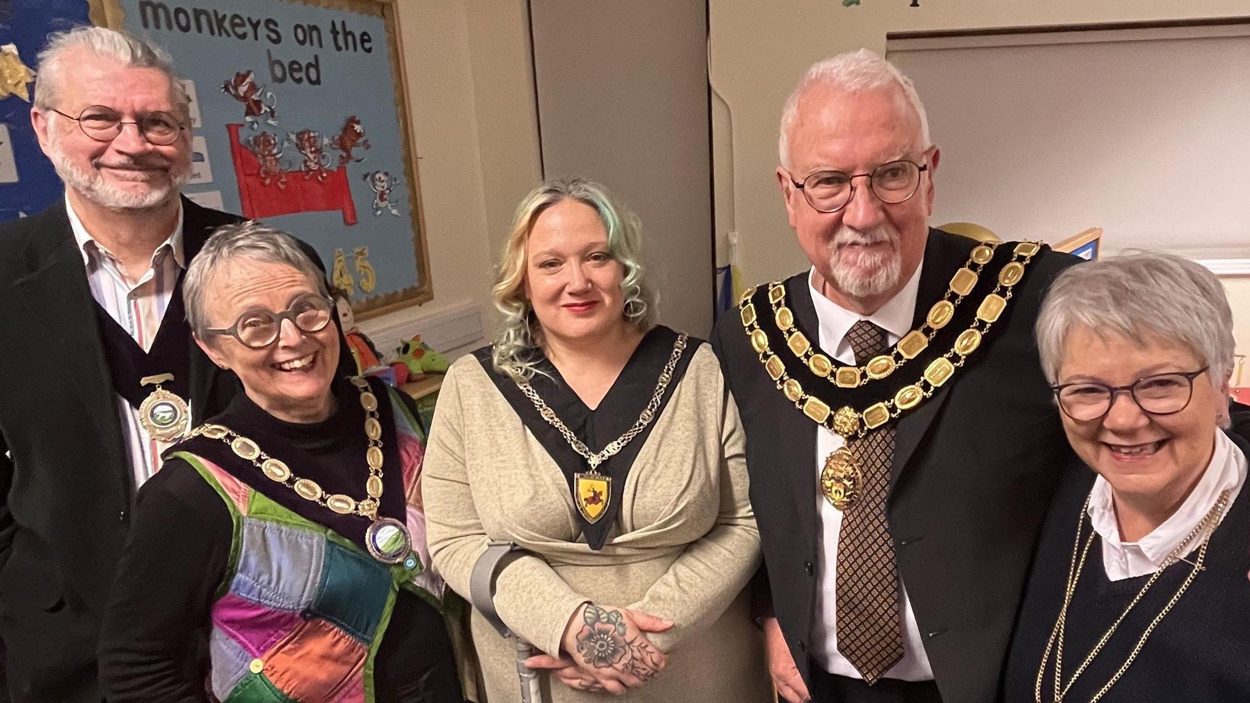 Five people looking at the camera wearing ceremonial uniforms including mayoral chains with the emblems of Westbury, Warminster and Trowbridge