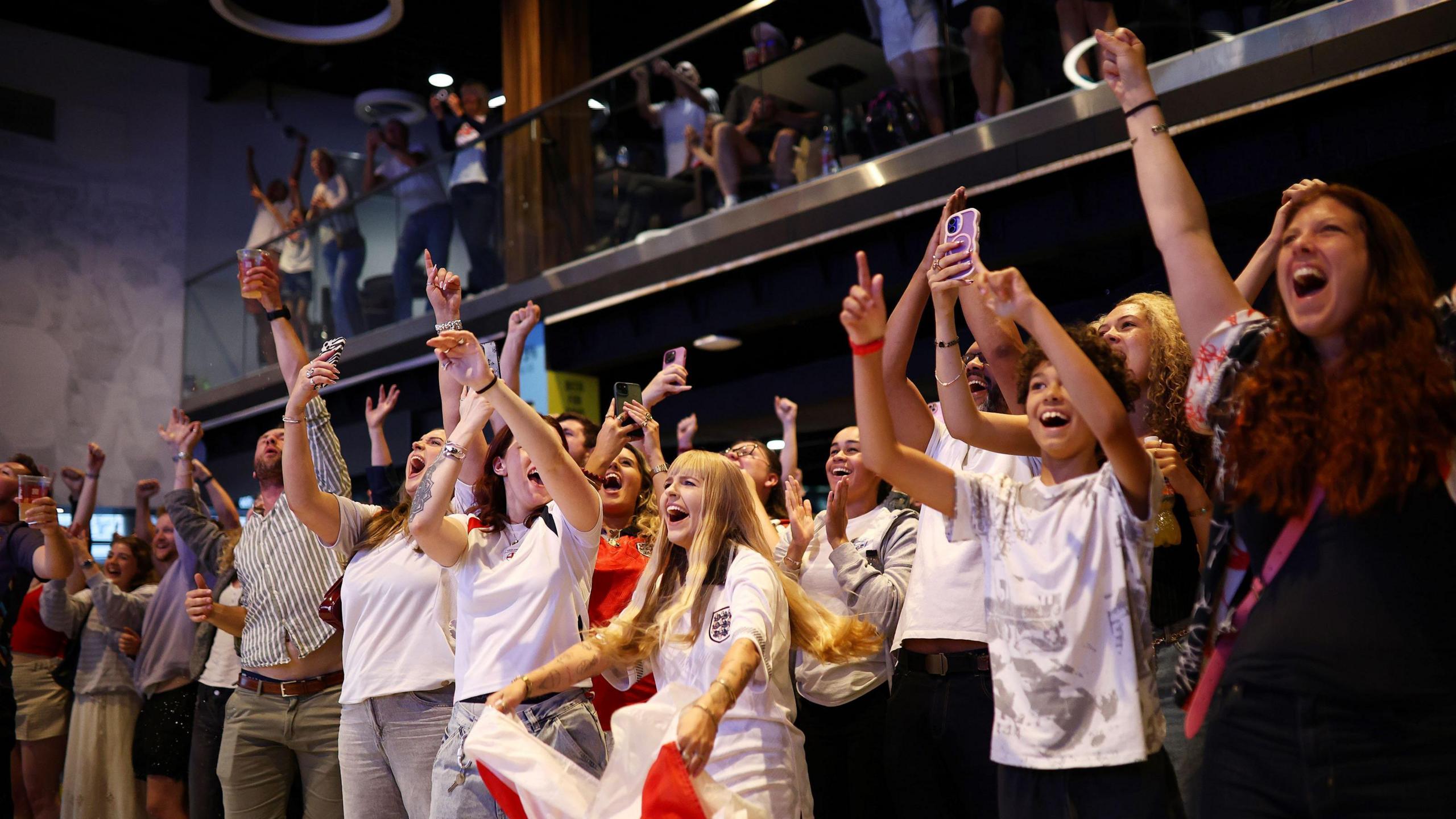 A group of women cheer England on against Spain in the final of the European Championships as they watch at Ashton Gate Stadium