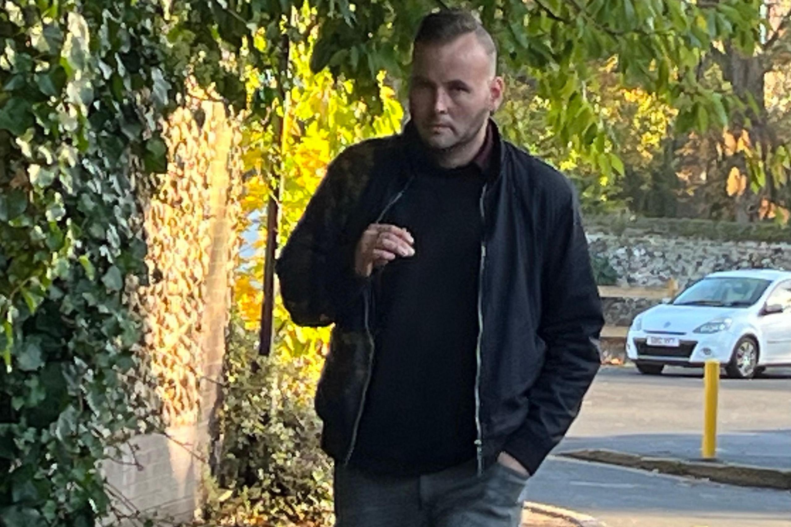 Wayne Finney arriving at Norwich Crown Court wearing a black jacket and smoking a cigarette.