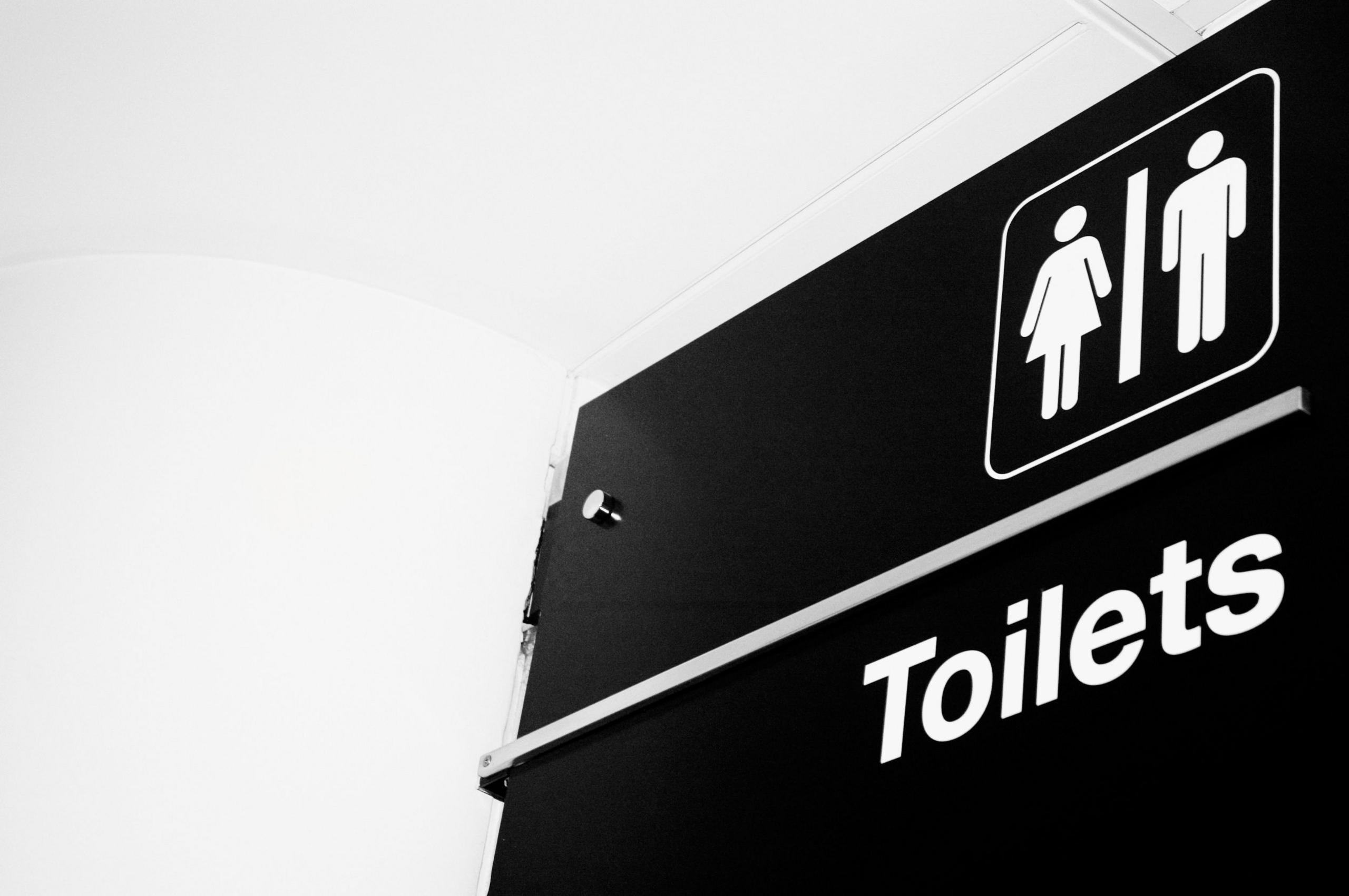 A black sign with the word "toilets" and the symbols of a woman and a man.