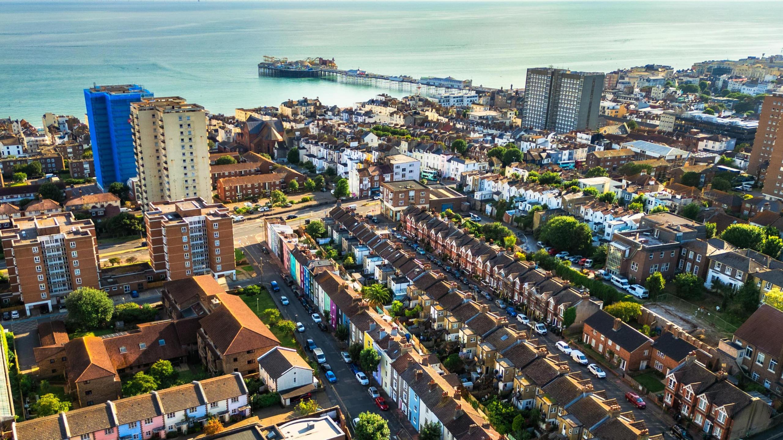 A view over homes and flats in Brighton. Brighton Pier and the sea is in the top of the image.