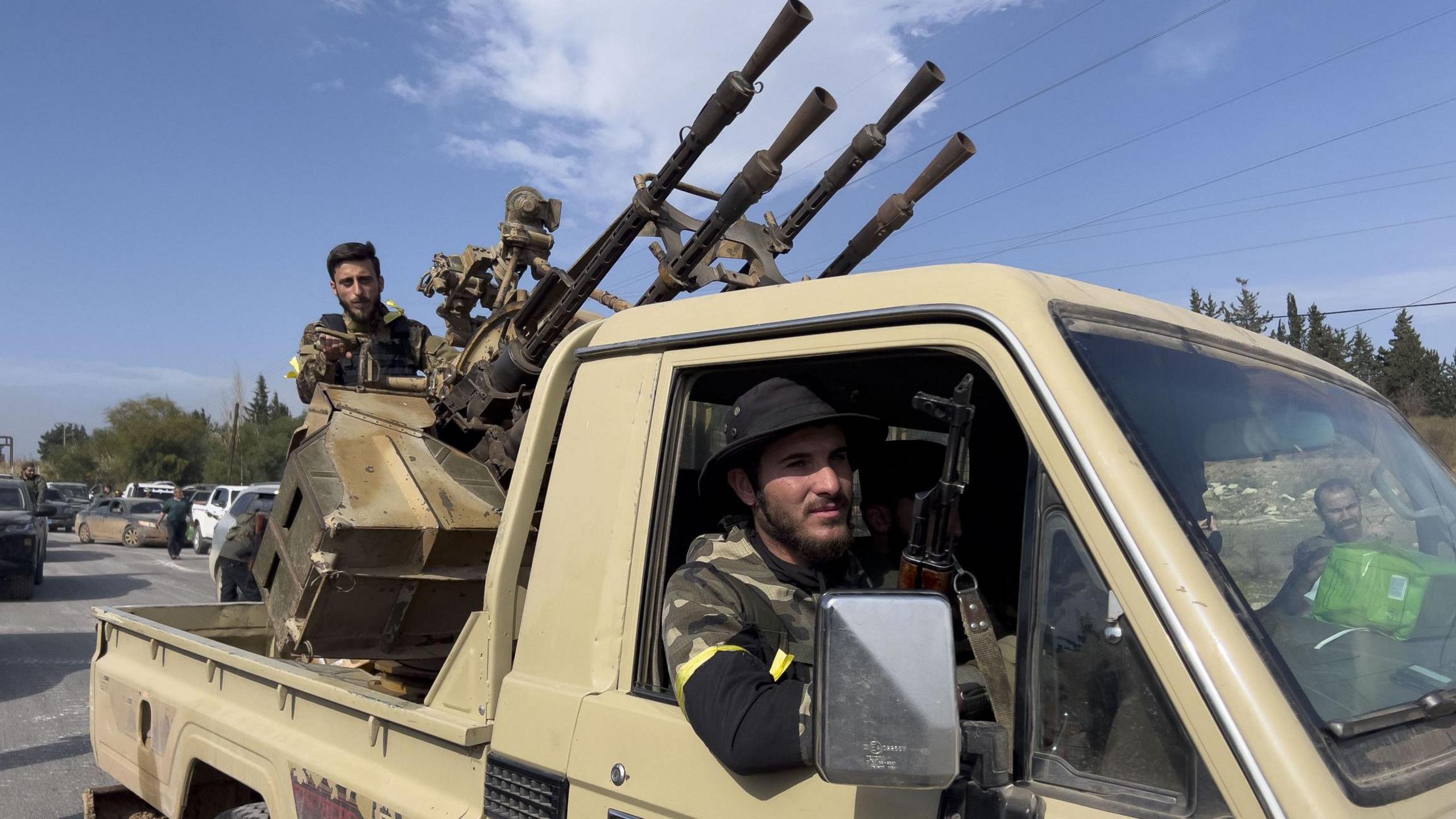 Members of the Syrian army  in a vehicle with weapons on the way to Latakia in Syria