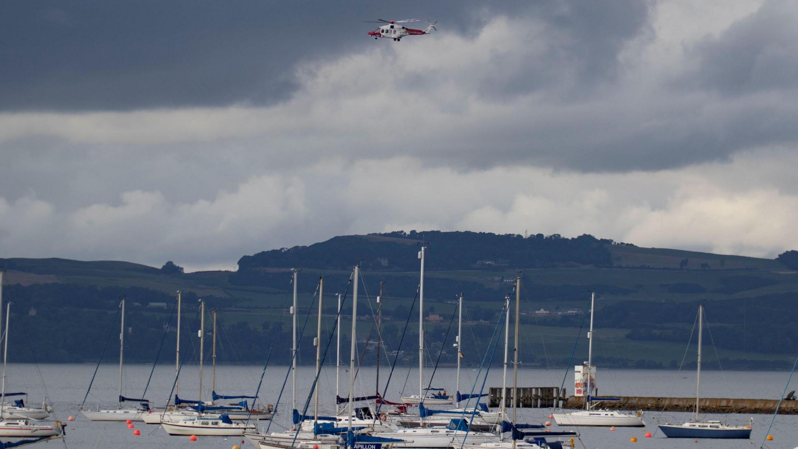 A search and rescue helicopter hovers over the water in Wardie Bay, where a woman has gone missing