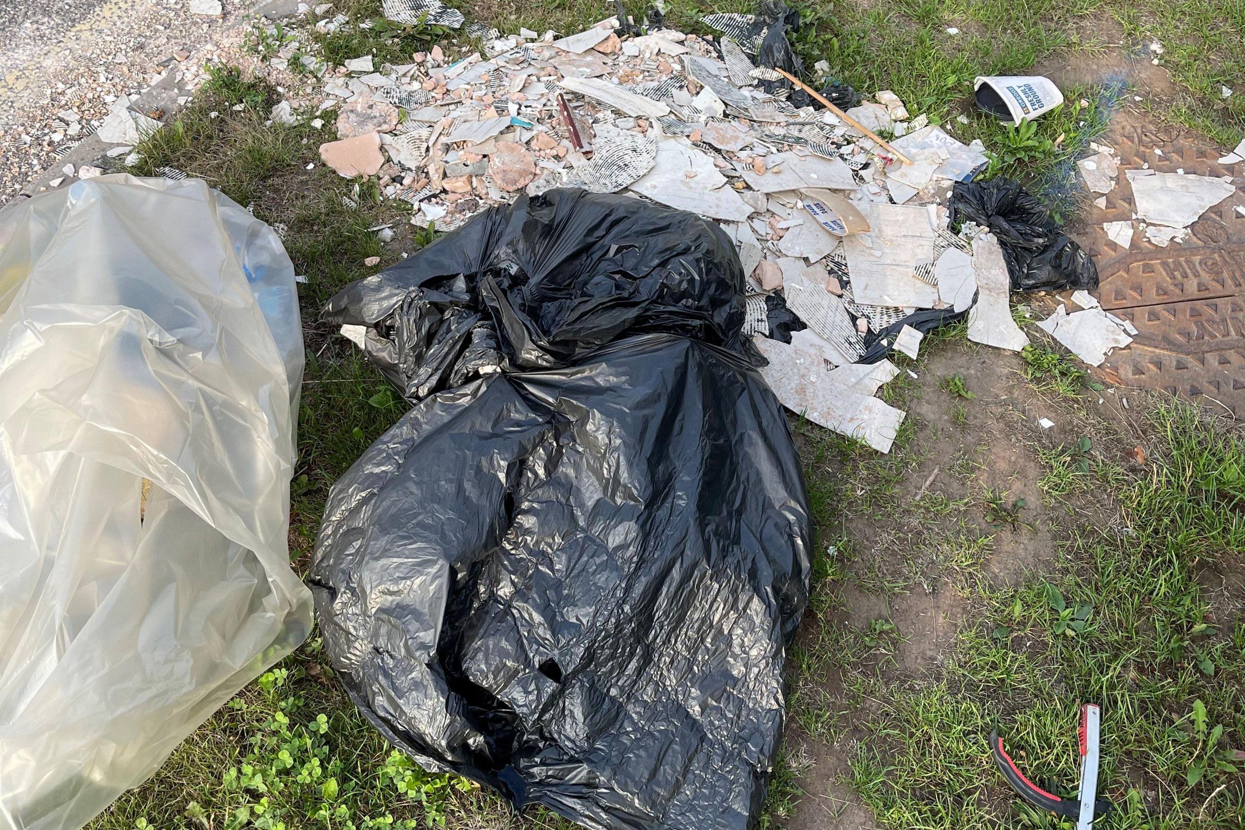 A black bin bag and litter strewn across the road