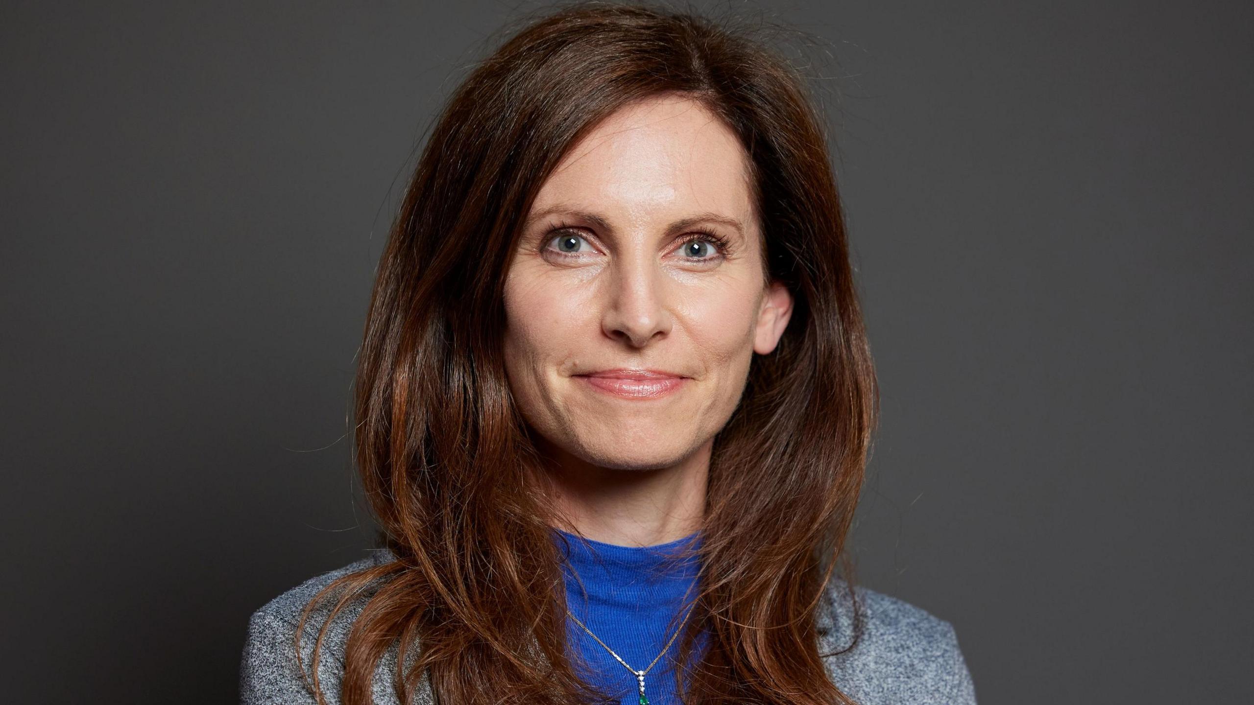 Chester South and Eddisbury MP Aphra Brandreth. She has long auburn hair and is wearing a blue sweater under a grey jacket.