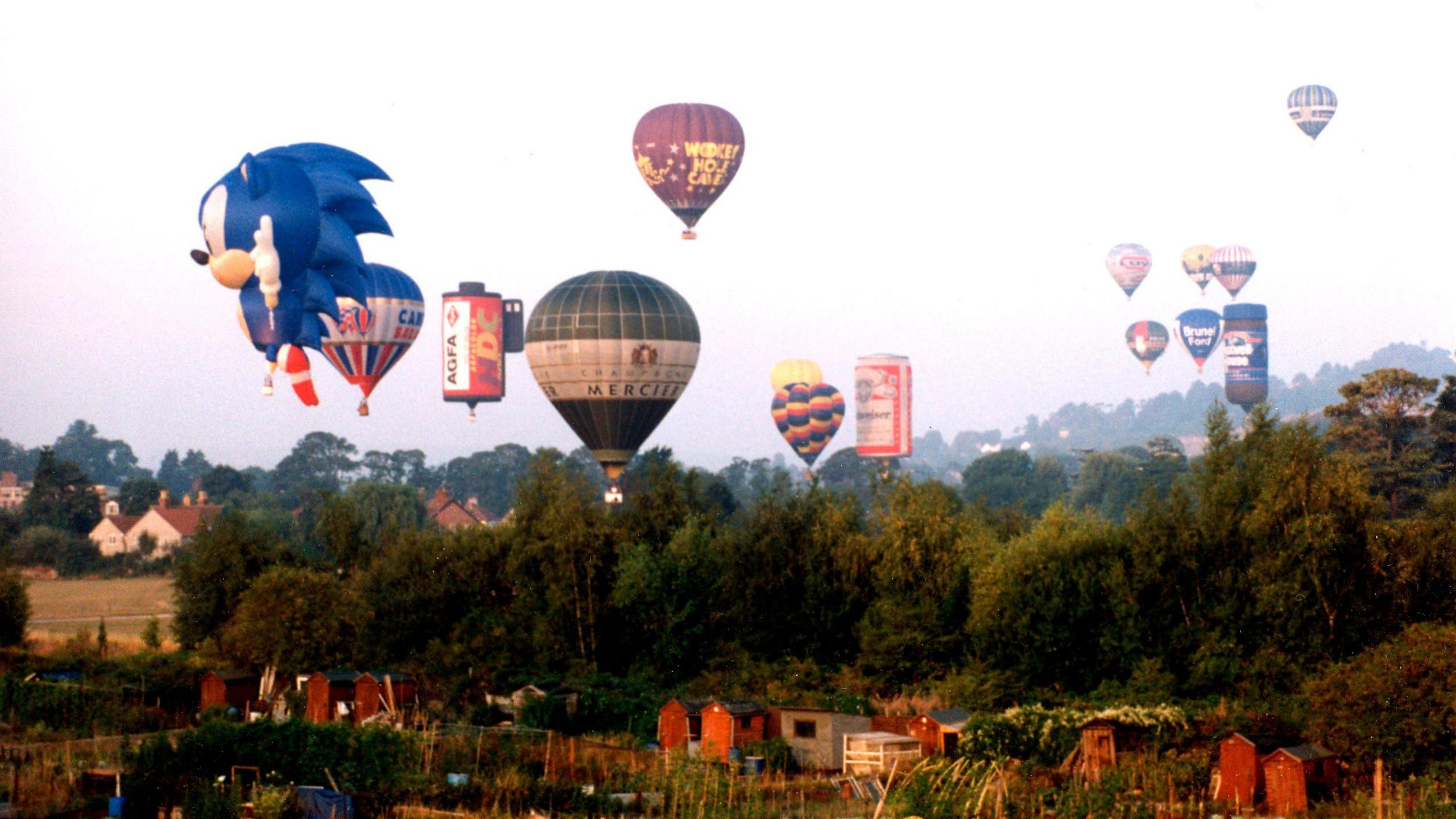 A view of hot air balloons flying over Bristol skyline, the lead balloon in the shape of the blue and white colouredSonic the Hedgehog