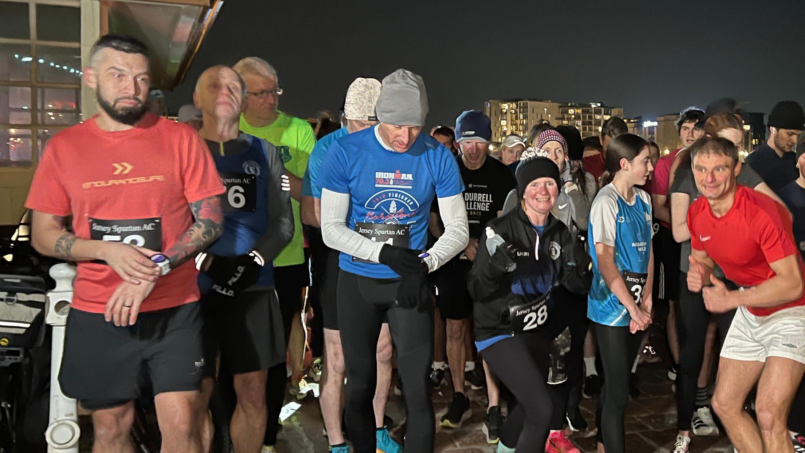 Runners look at their watches as they get ready to start the race.