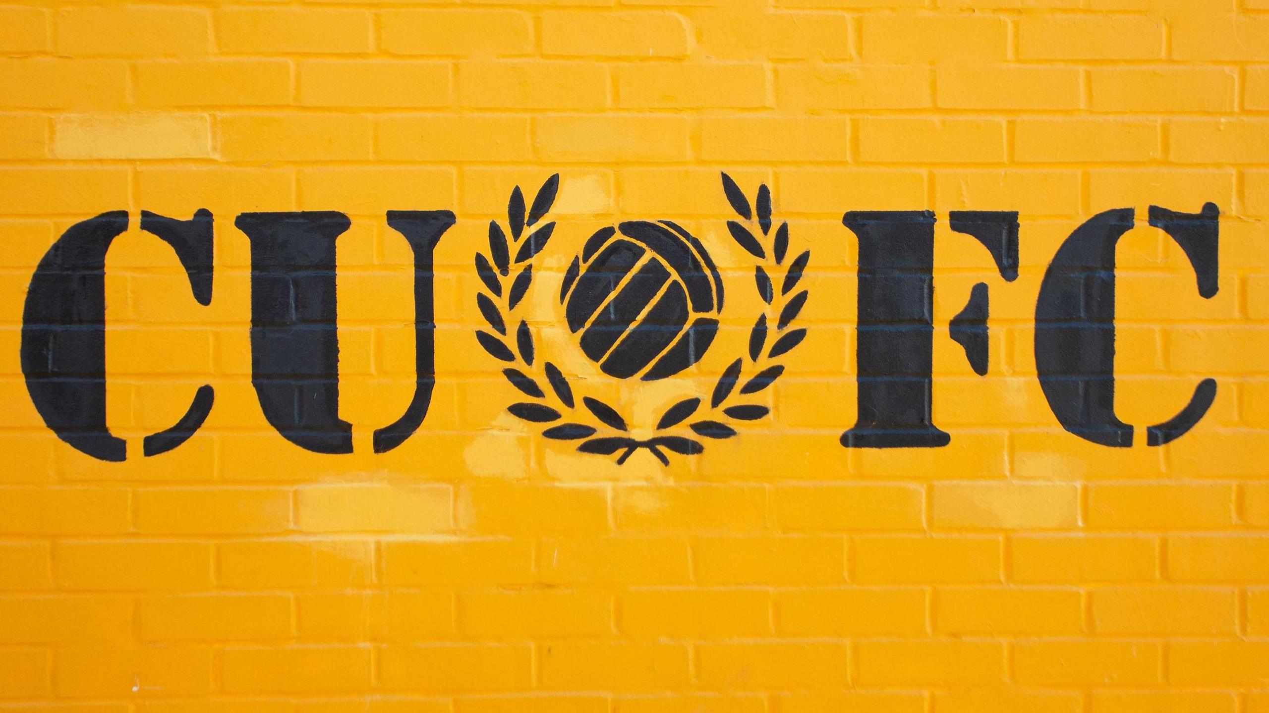 Yellow wall decorated with Cambridge United FC initials