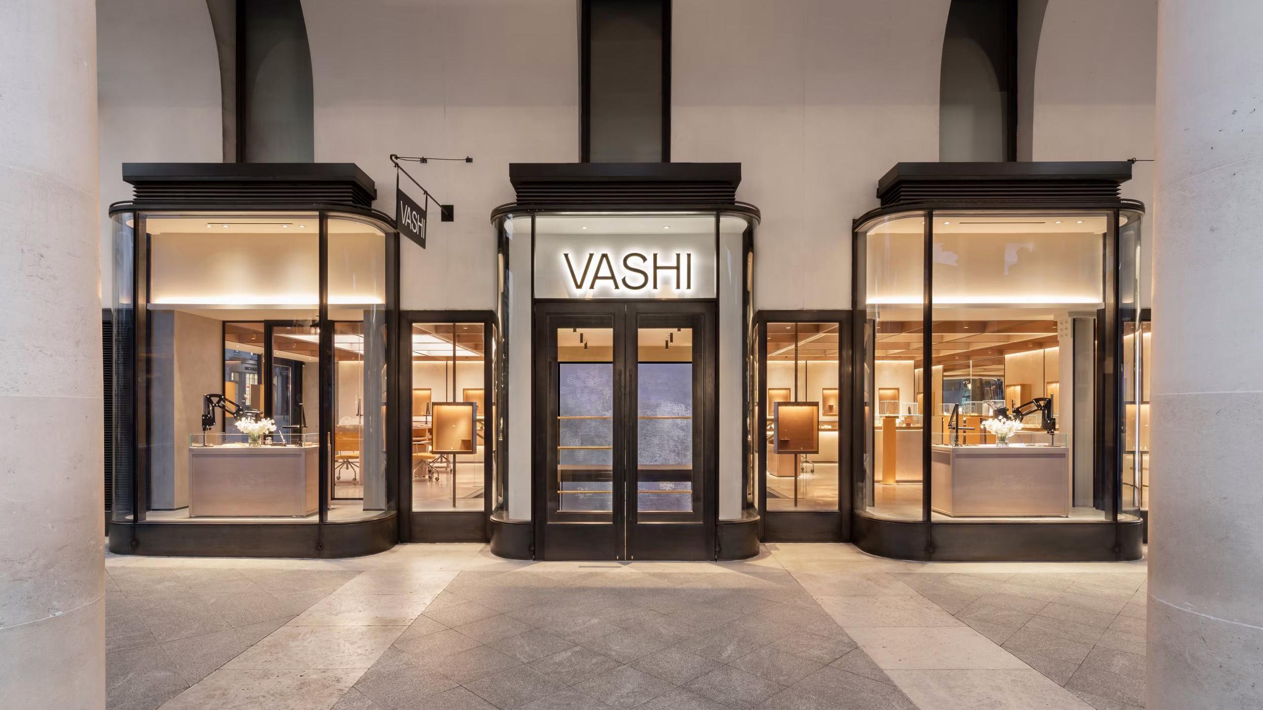 The large Vashi store in Covent Garden, with the entrance in the middle of the picture and two large bay windows either side. Above the door, the Vashi logo in a minimalist san serif type face is brightly illuminated.
