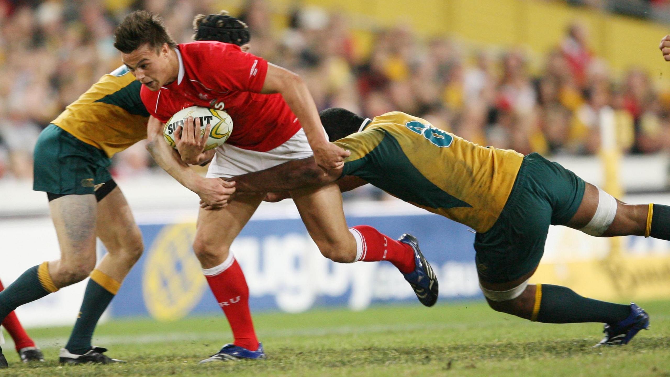 Wales wing Chris Czekaj is tackled by Rocky Elsom and Sam Norton-Knight 