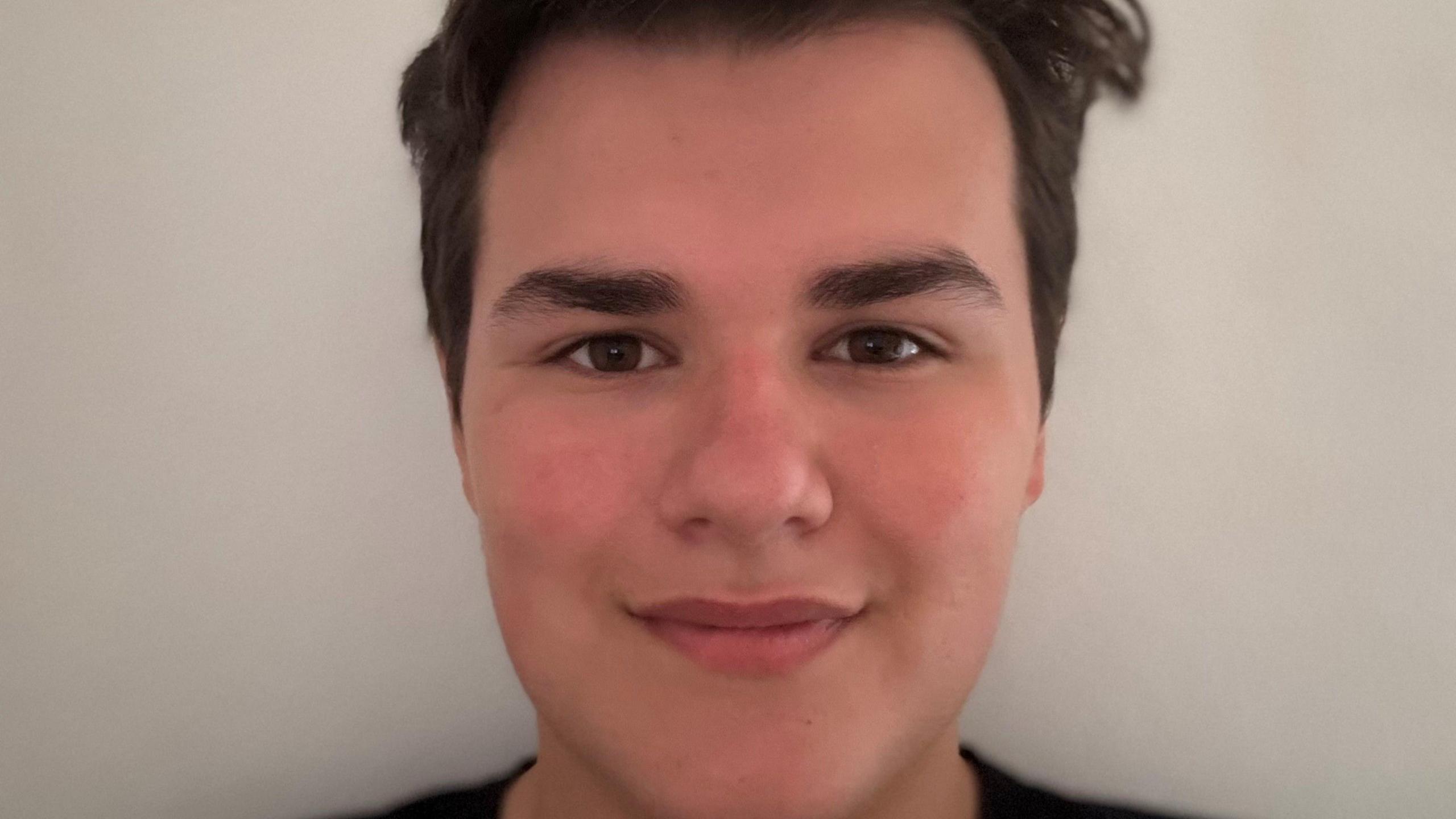 A headshot of Milton, who is smiling and has brown hair. 