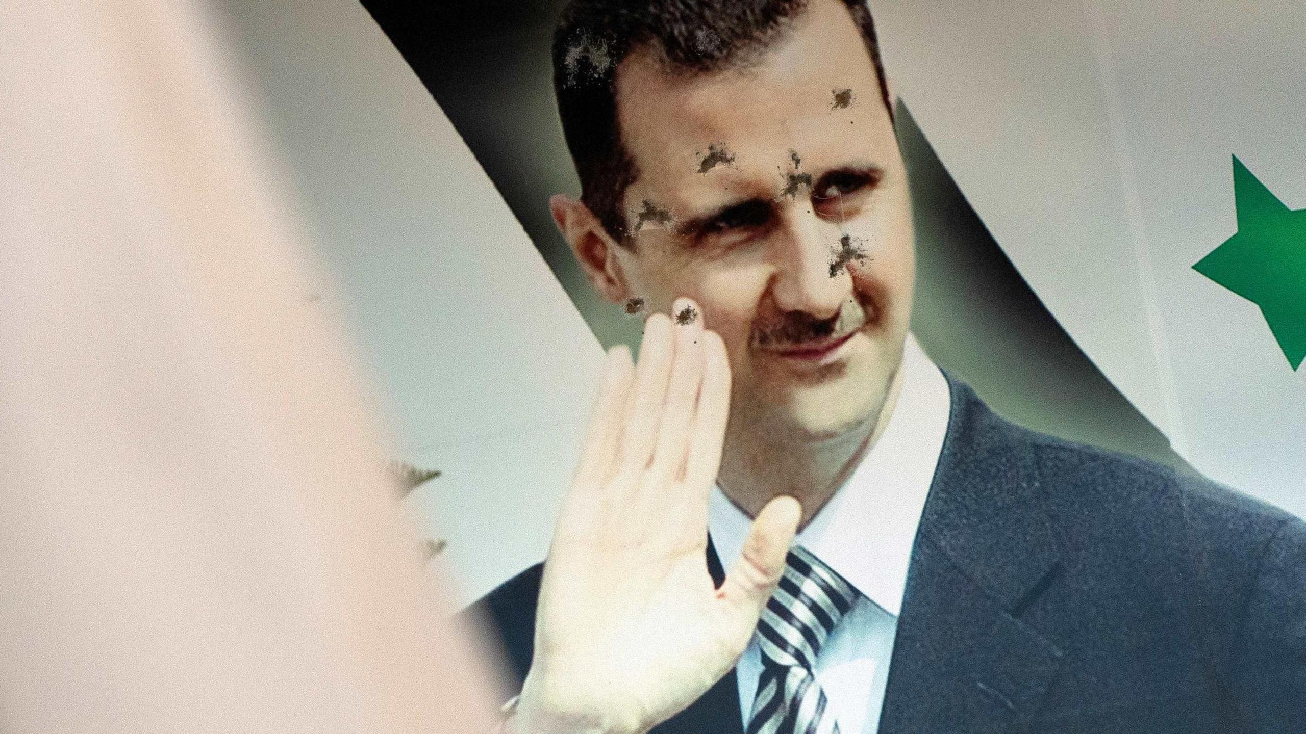 A poster of Assad riddled with bulletholes.