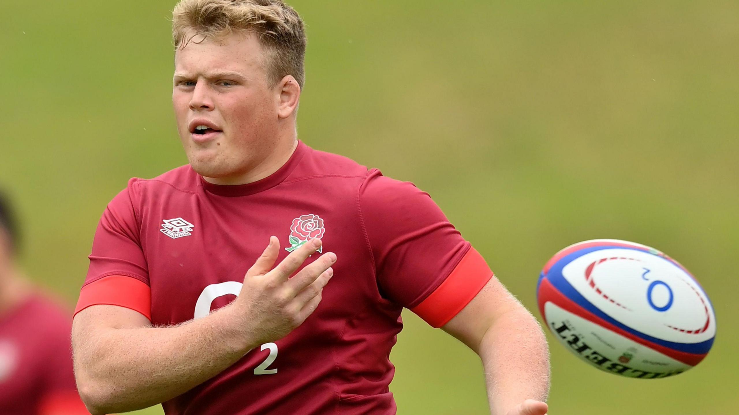 Fin Baxter passes a ball during an England training session