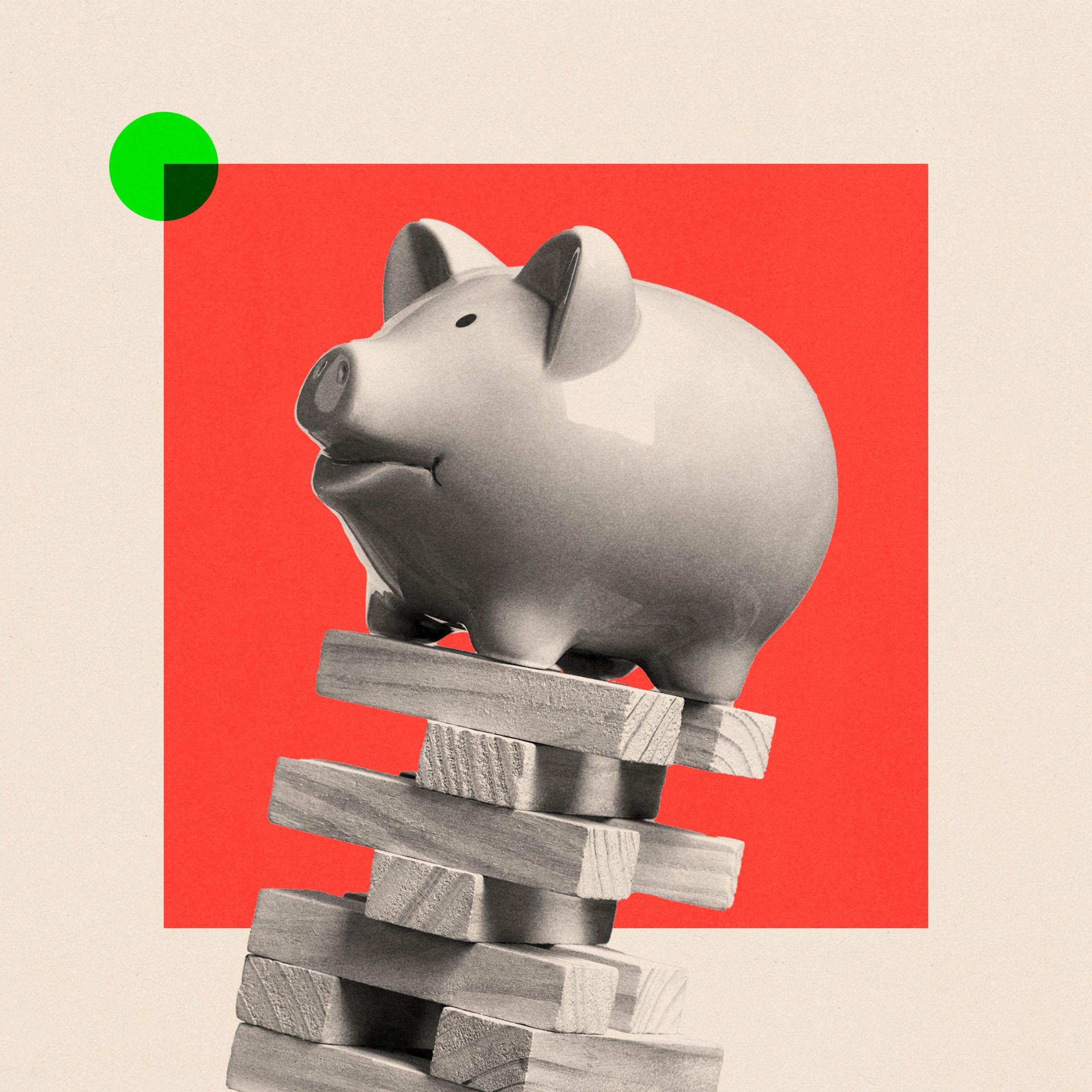 A piggy bank balanced on top of some falling wooden blocks