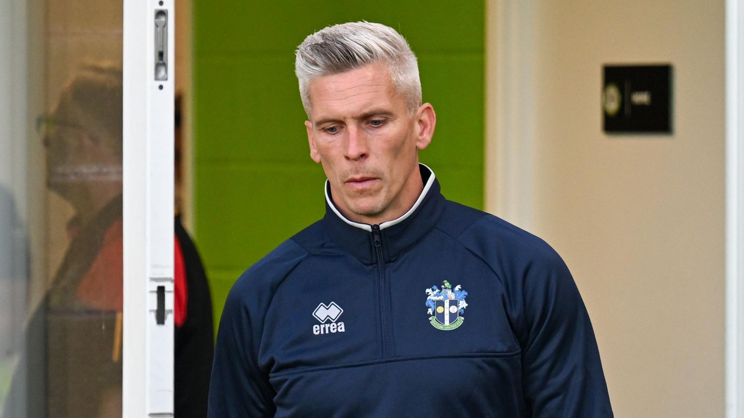 Steve Morison walking out of a door at Forest Green's New Lawn before a match