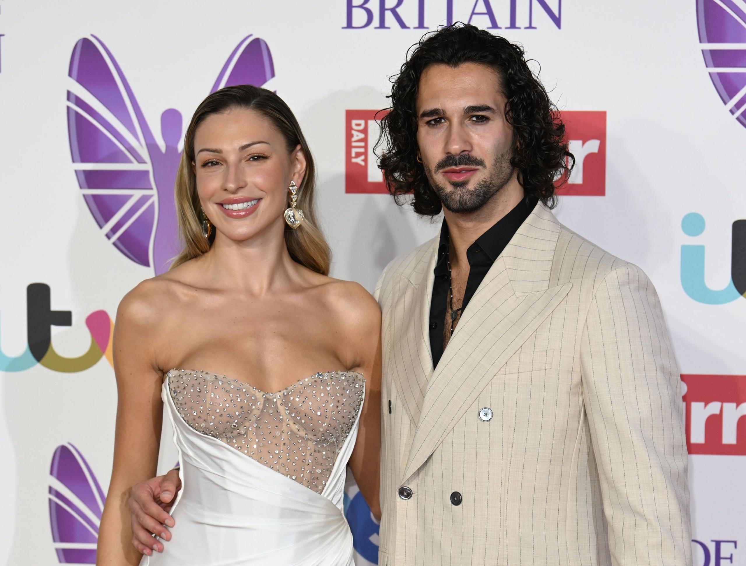 Zara Mcdermott with Strictly partner Graziano Di Prima. Graziano has his hand on Zara's waist. Both are posing ifnront of Pride of Britain Awards backdrop 
