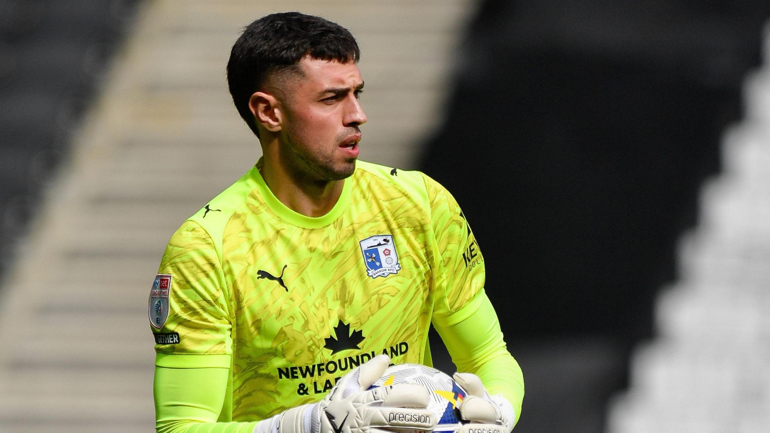 Wyll Stanway wearing a lime green goalkeeper kit for Barrow