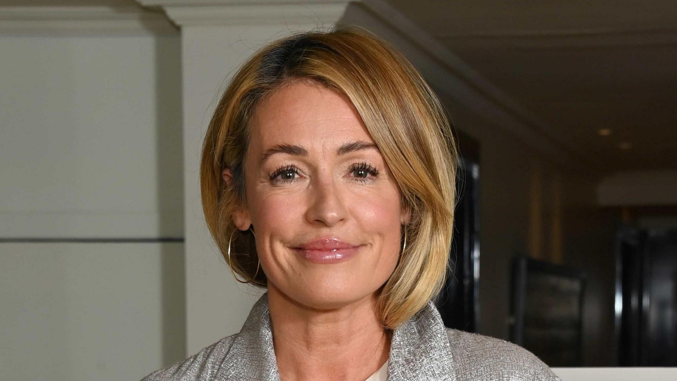 Cat Deeley wearing a grey jacket and large hoop earrings