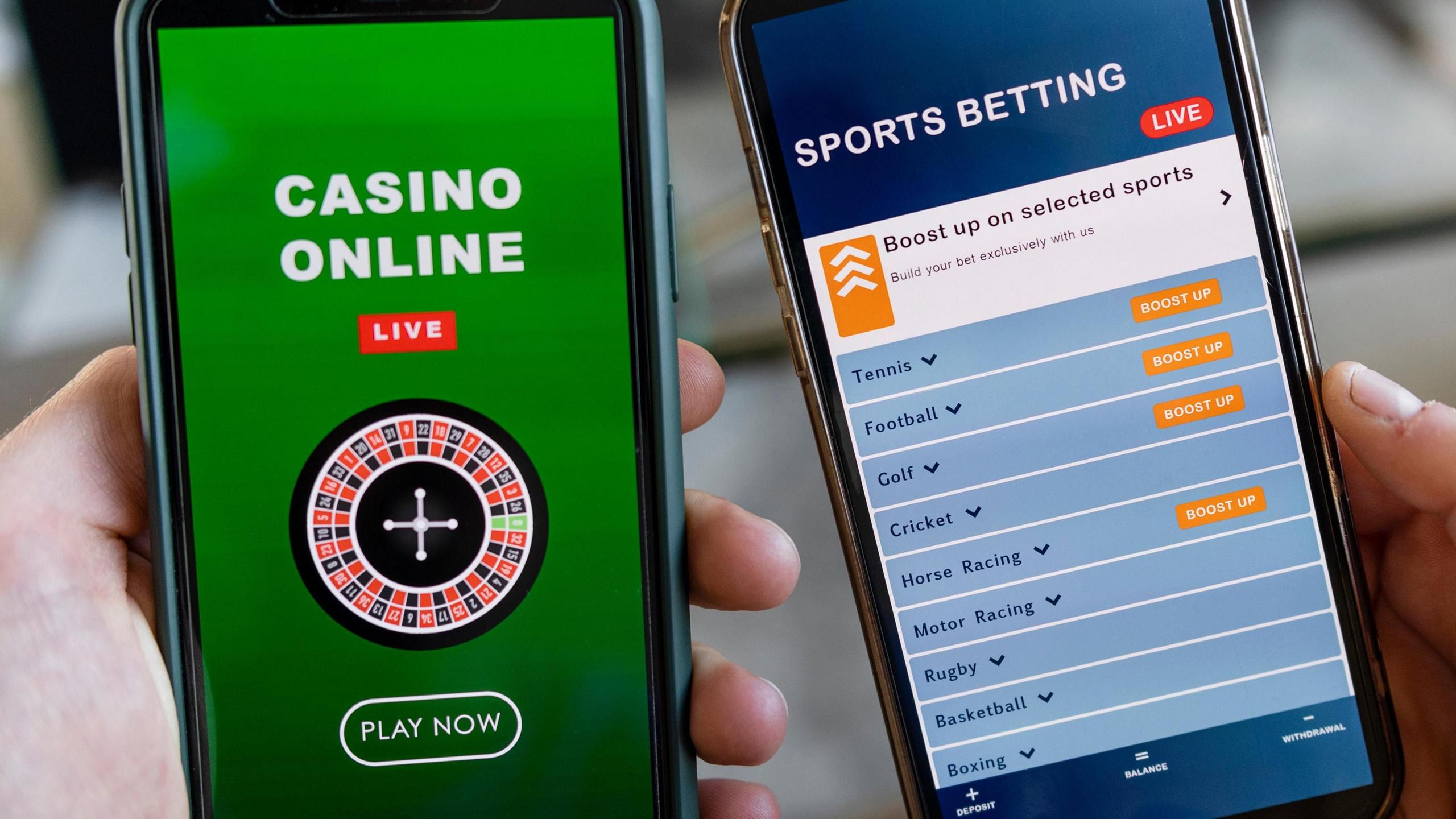 Two smart phones, one with a green online casino app on its screen and another with a blue sports betting app.