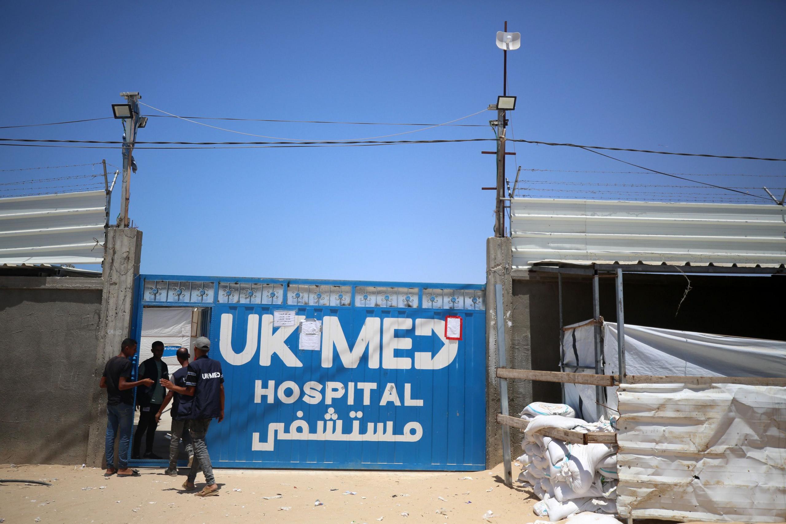 A blue metal gate bearing the words 'UK Med Hospital'
