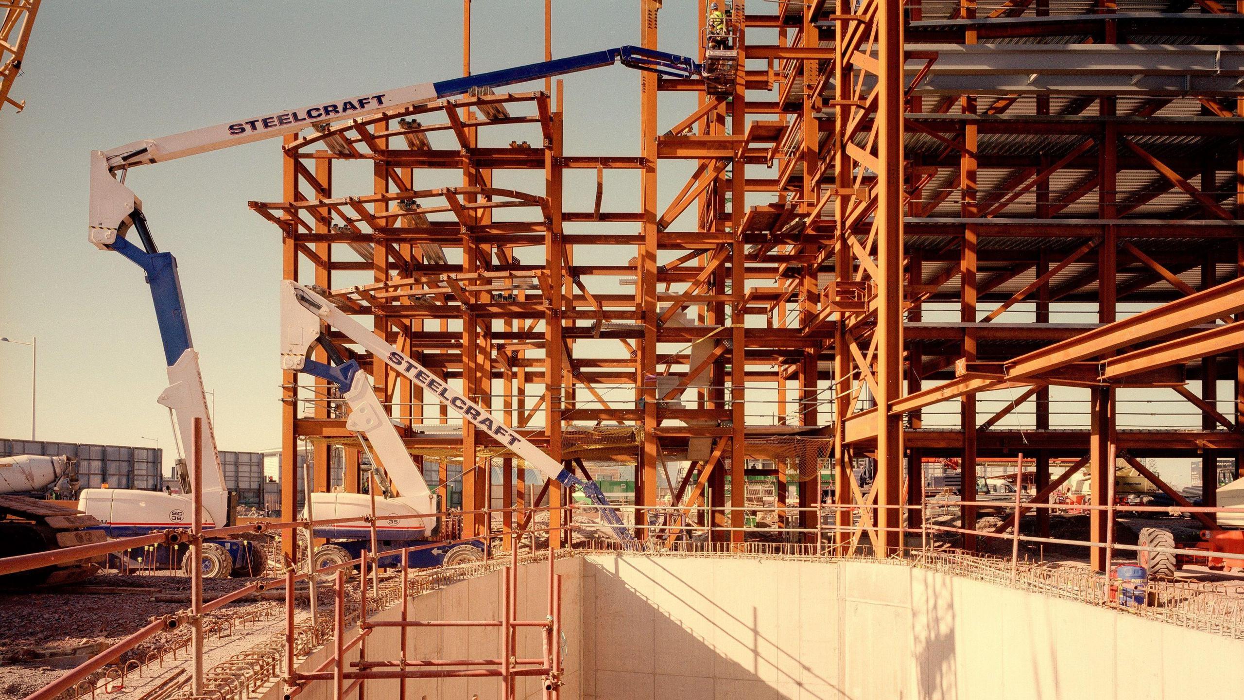 Builders assemble metal beams and girders to begin building the iconic Wales Millennium Centre.