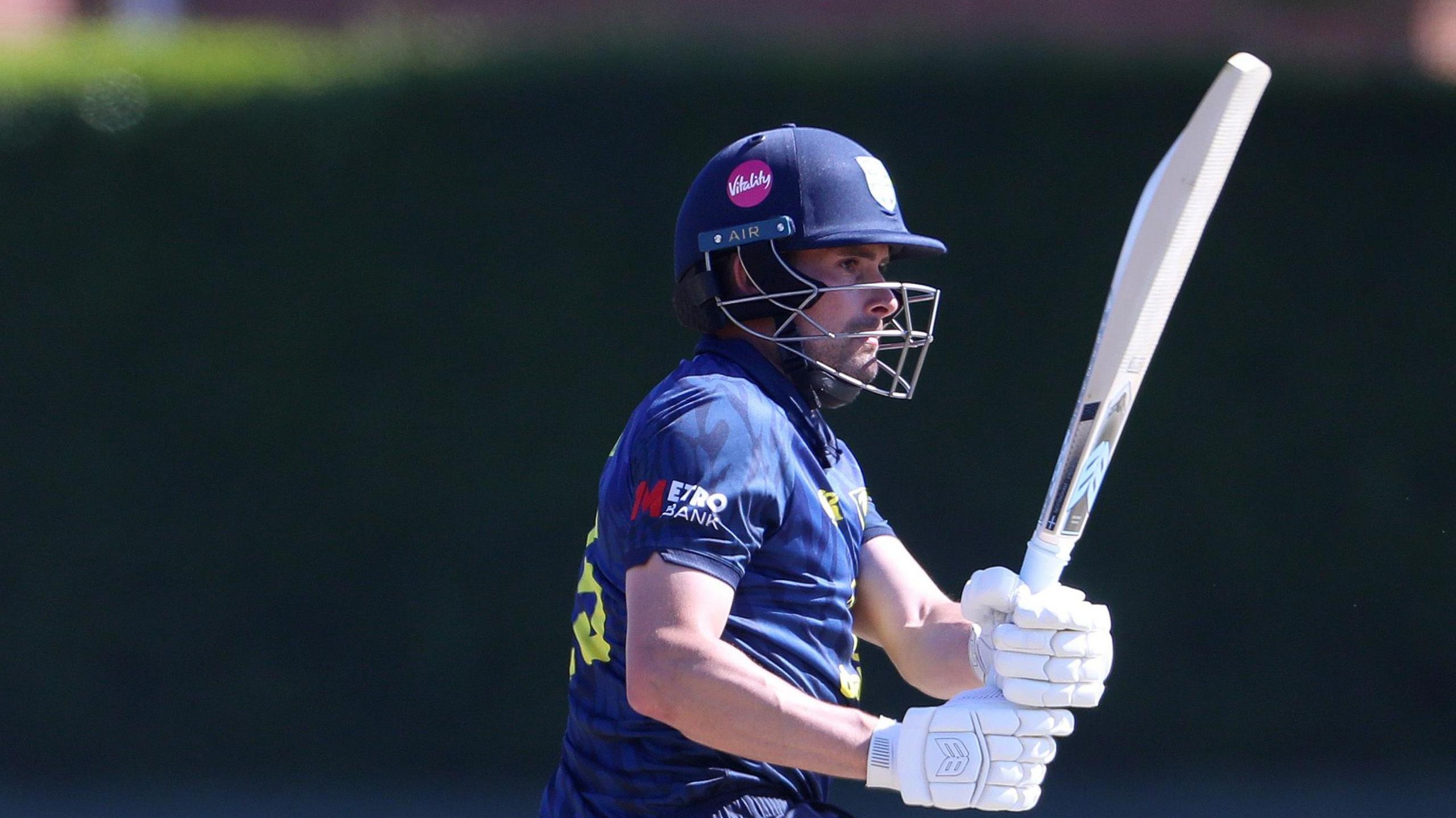 Left-handed Will Rhodes hits a pull shot while batting for Durham