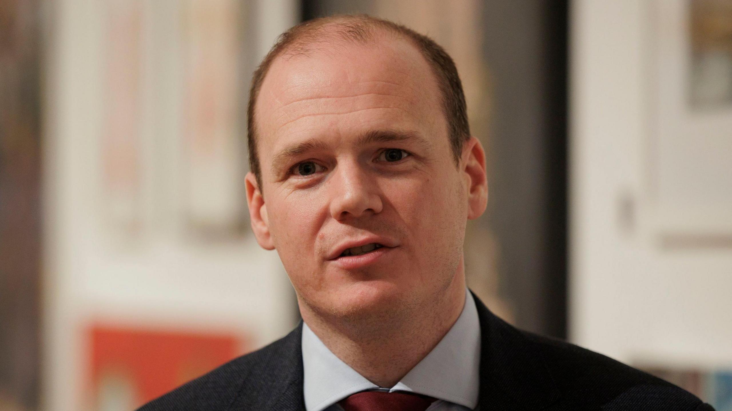 Gordon Lyons wearing a suit jacket with a shirt and tie