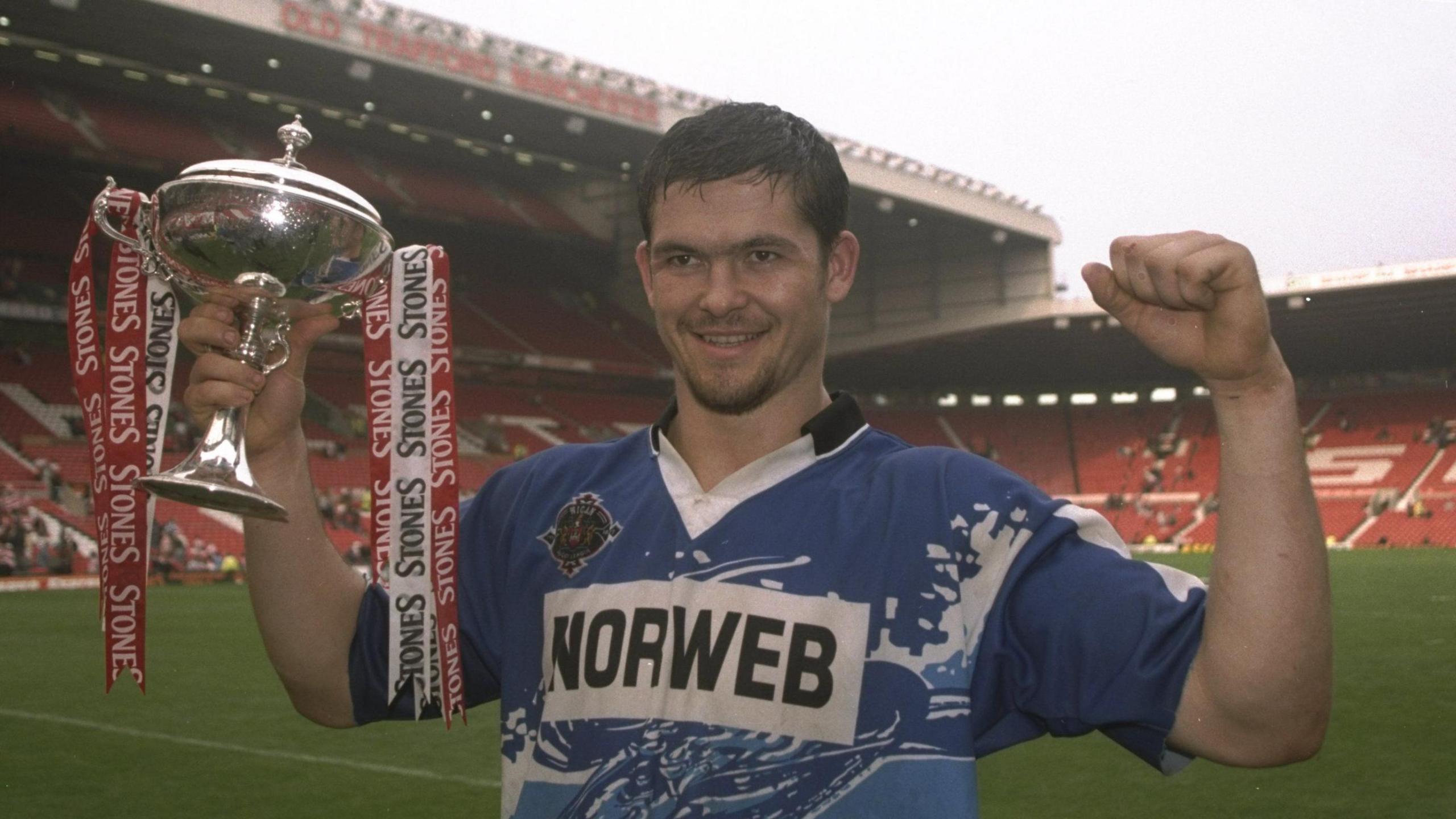 Andy Farrell in a Wigan shirt holding a trophy