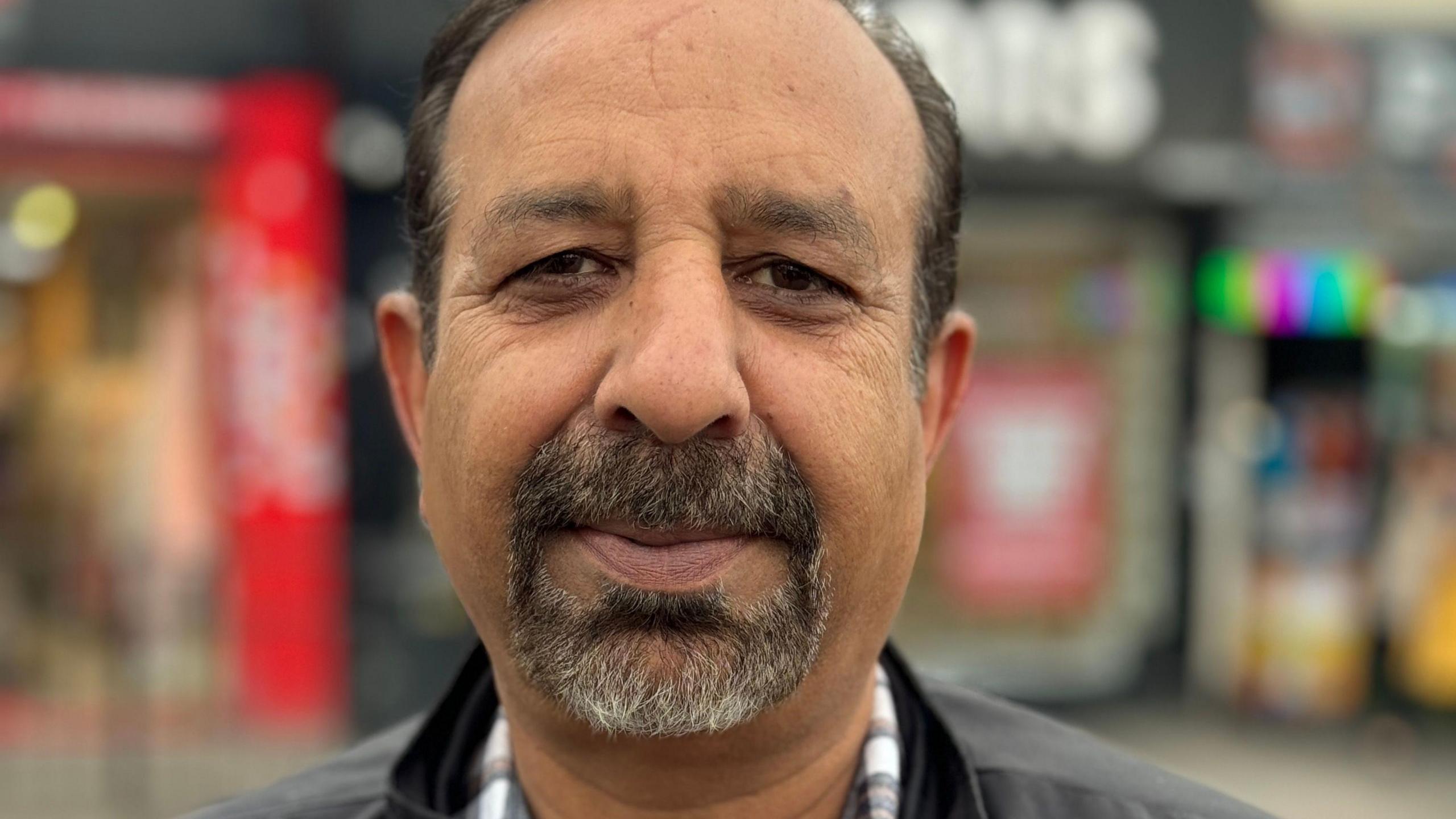 A man with a black and grey beard in a black jacket