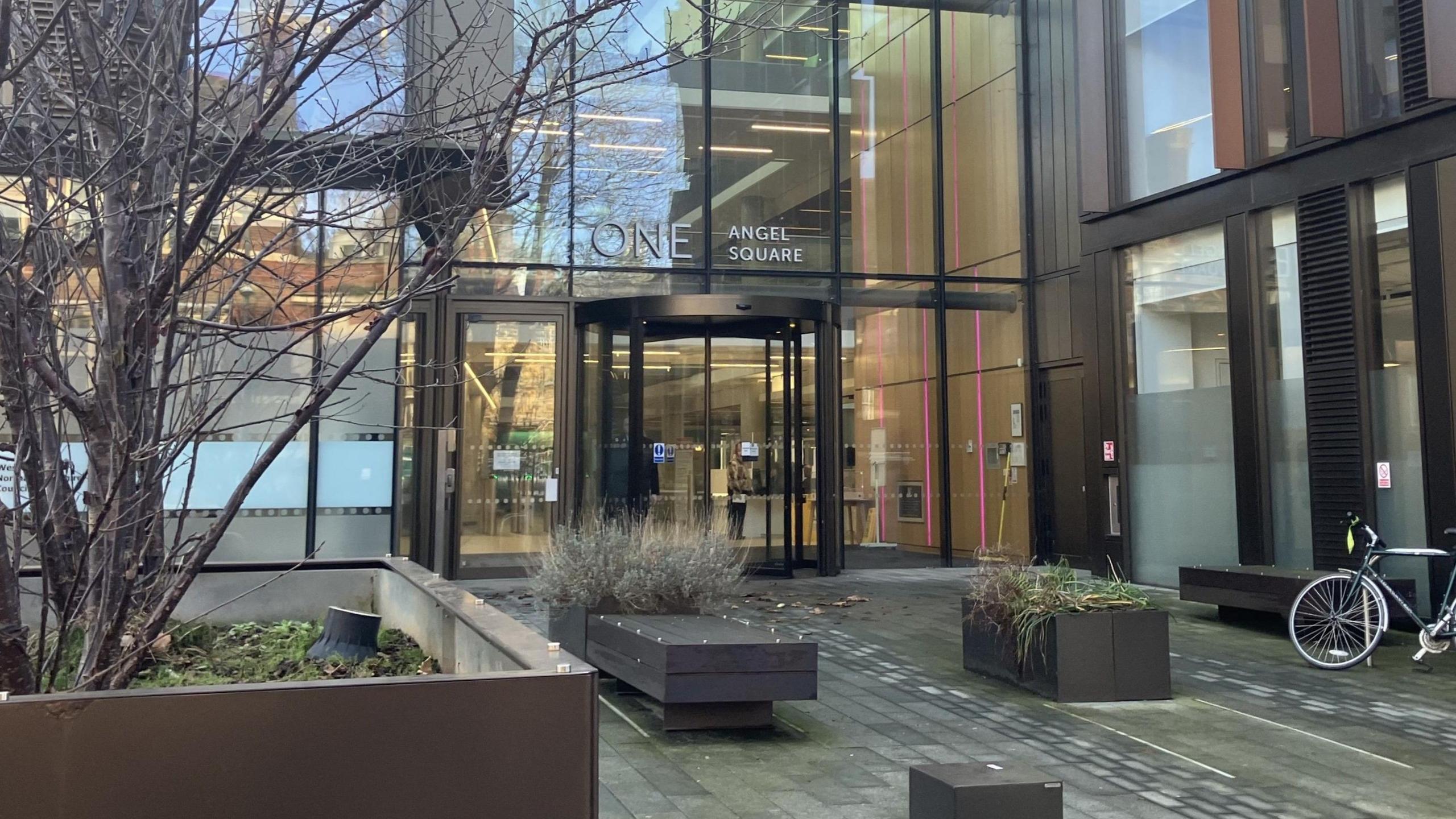 The entrance to One Angel Square, the headquarters of West Northamptonshire Council which is a modern glass fronted construction.