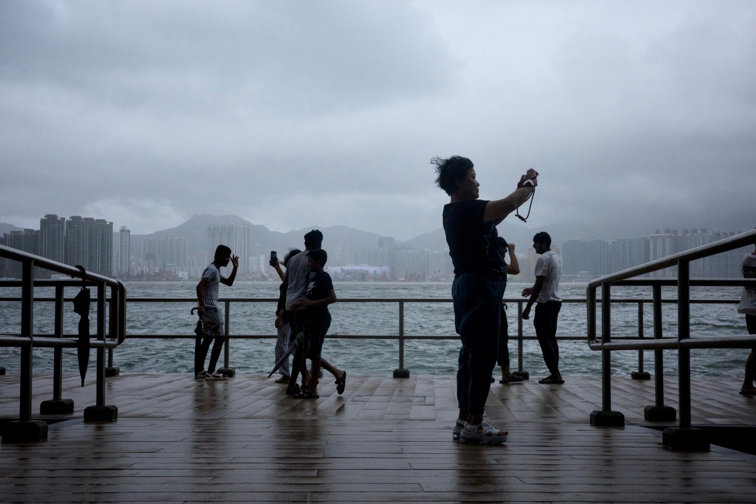 People watch waves along the seaside as super typhoon Ragasa moves away on September 24, 2025 in Hong Kong, China. 