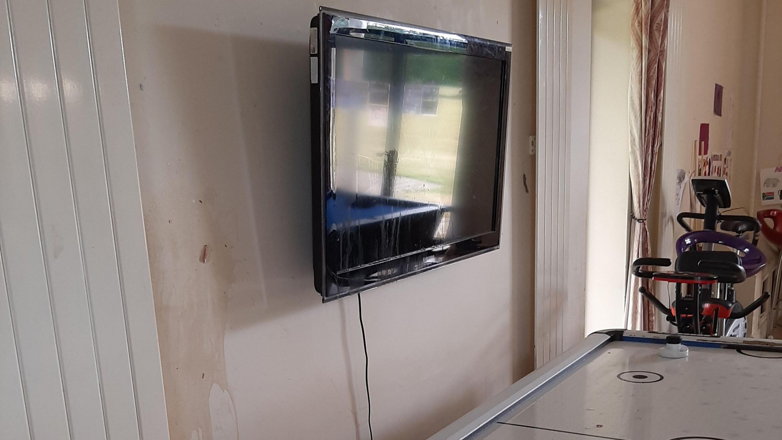 Youth club room shows TV on wall covered in cooking oil and eggs on the white walls